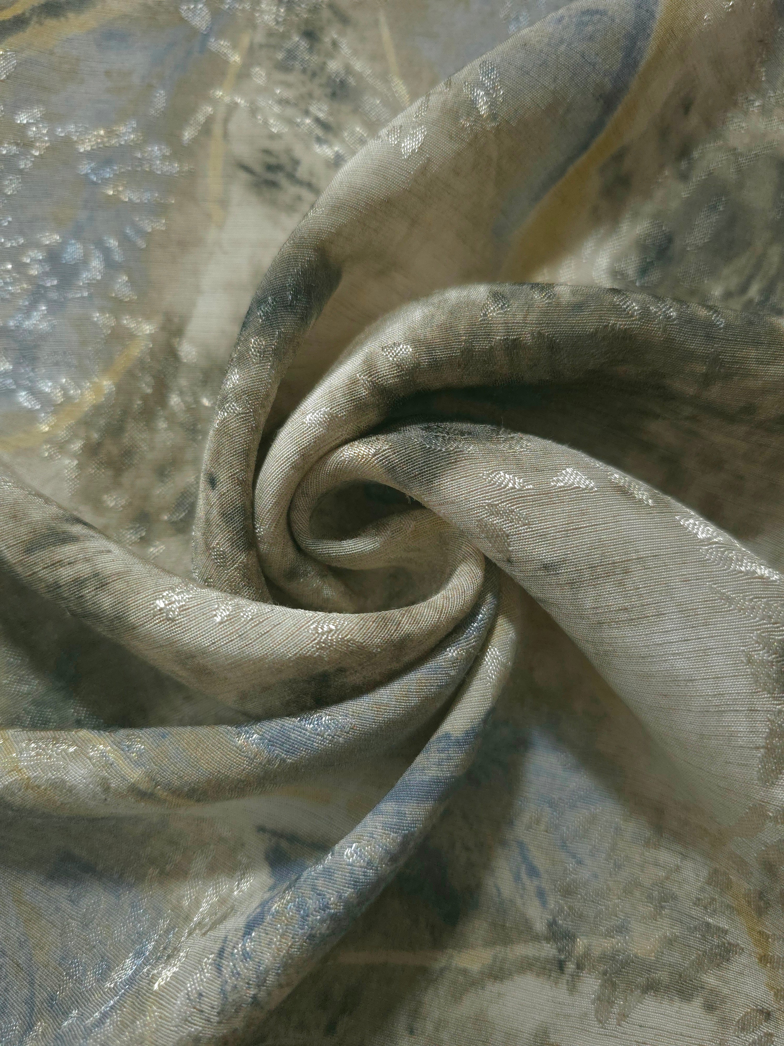 Blue botanical shadow jacquard fabric folded to show linen-like texture, body and apparel drape.
