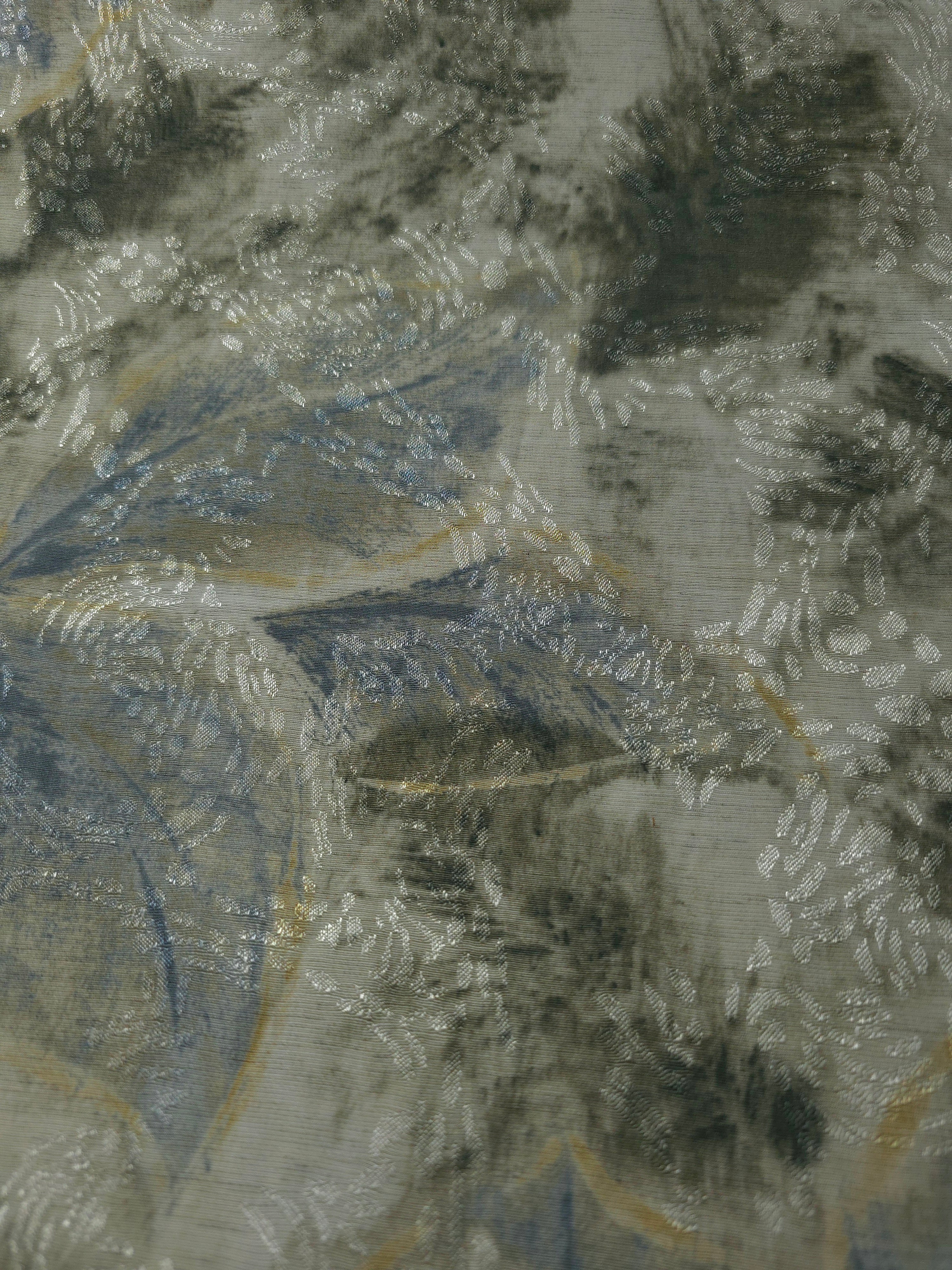 Blue botanical shadow linen-look jacquard fabric pattern overview with tonal woven leaf design.