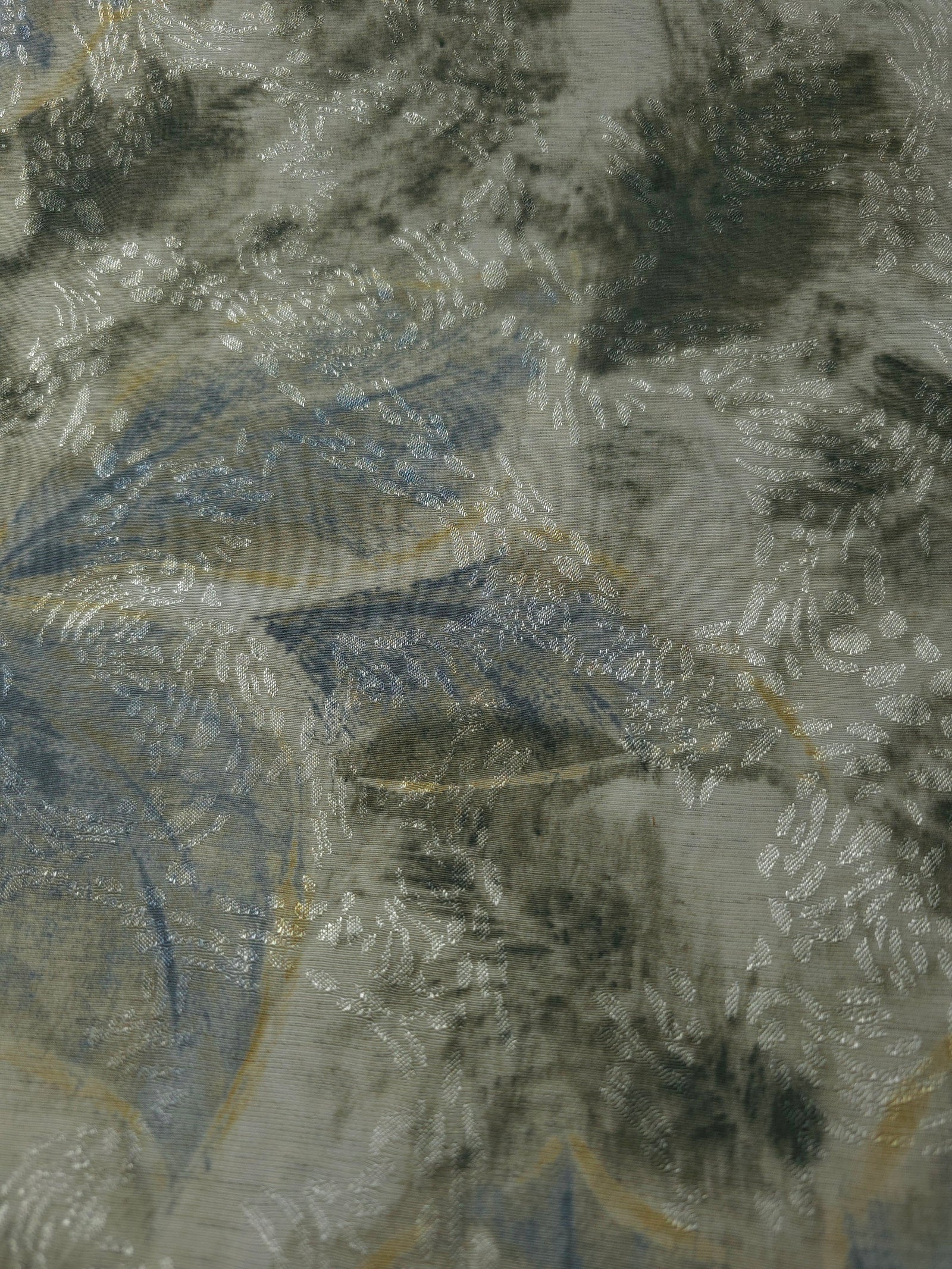 Blue botanical shadow linen-look jacquard fabric pattern overview with tonal woven leaf design.