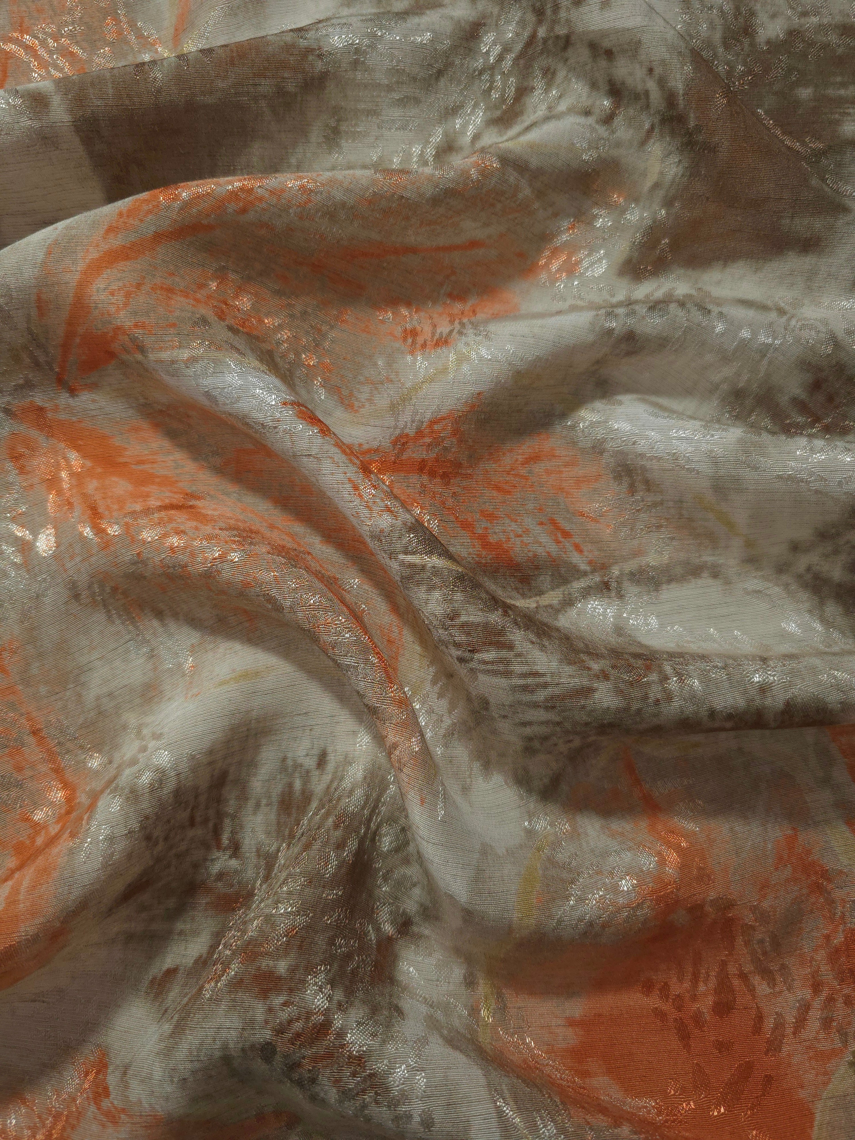 Orange botanical shadow jacquard fabric draped to show soft structure, movement and linen-like surface.