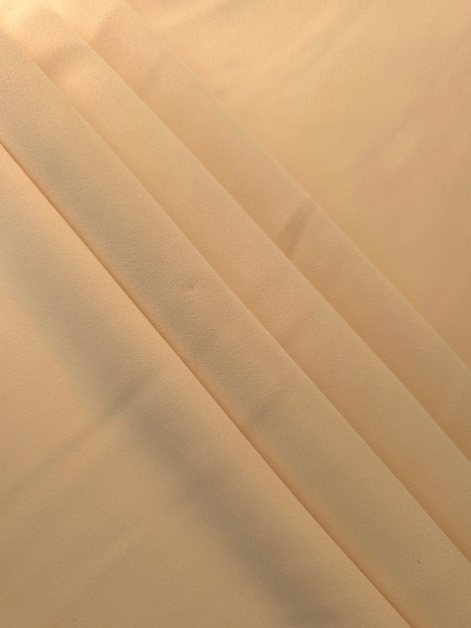 Camel Beige Korean crepe in layered folds, showing soft structure and slight mechanical stretch for skirts
