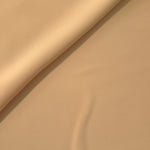 Soft fold of Camel Beige opaque polyester crepe showing fluid dressmaking drape for dresses and skirts
