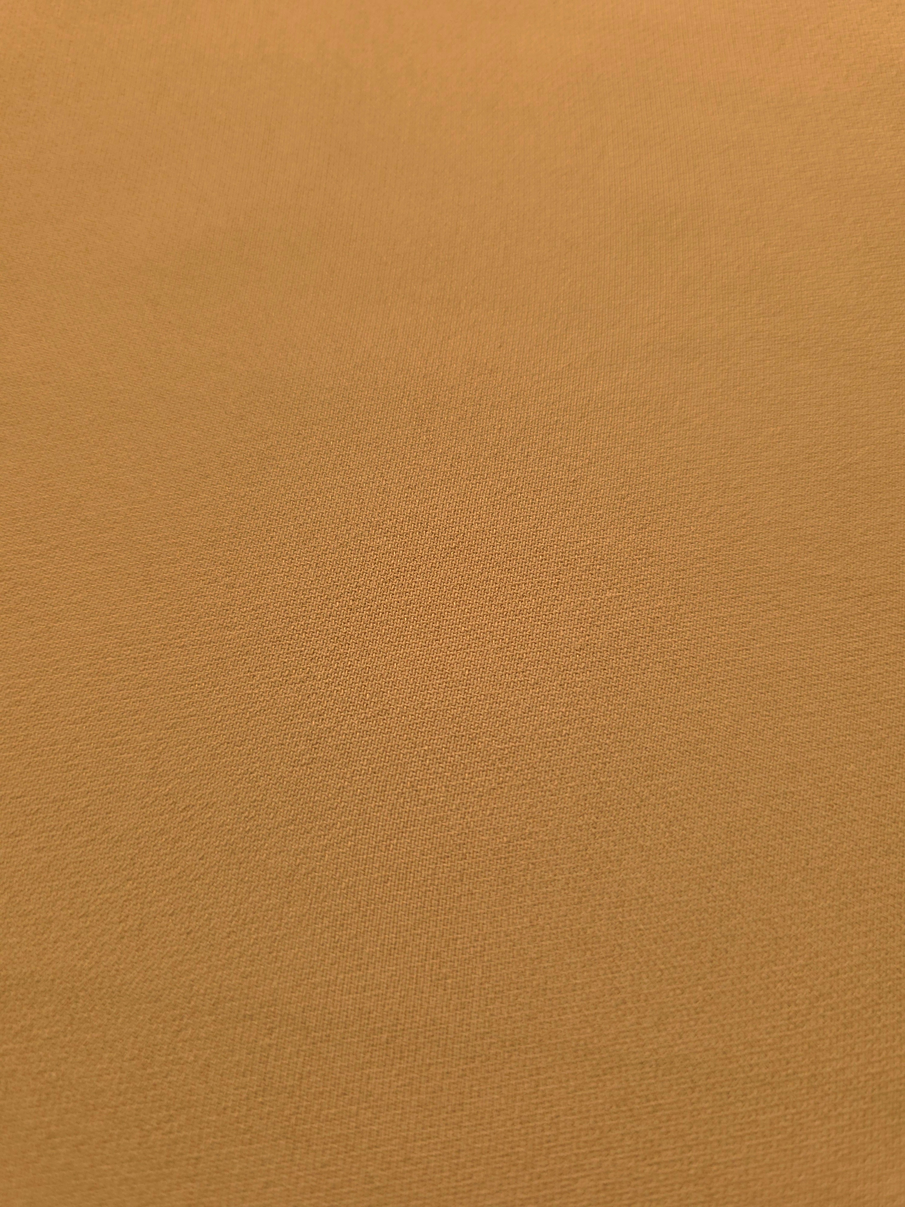 Close-up of Caramel Brown mechanical polyester crepe showing fine woven texture and a smooth silky-soft hand