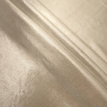 Layered Champagne Beige metallic stretch fabric with reflective foil finish, showing flexible body for dancewear and occasion fashion
