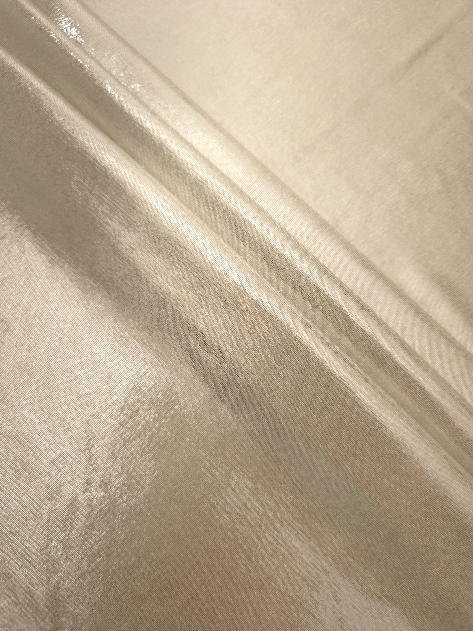 Layered Champagne Beige metallic stretch fabric with reflective foil finish, showing flexible body for dancewear and occasion fashion