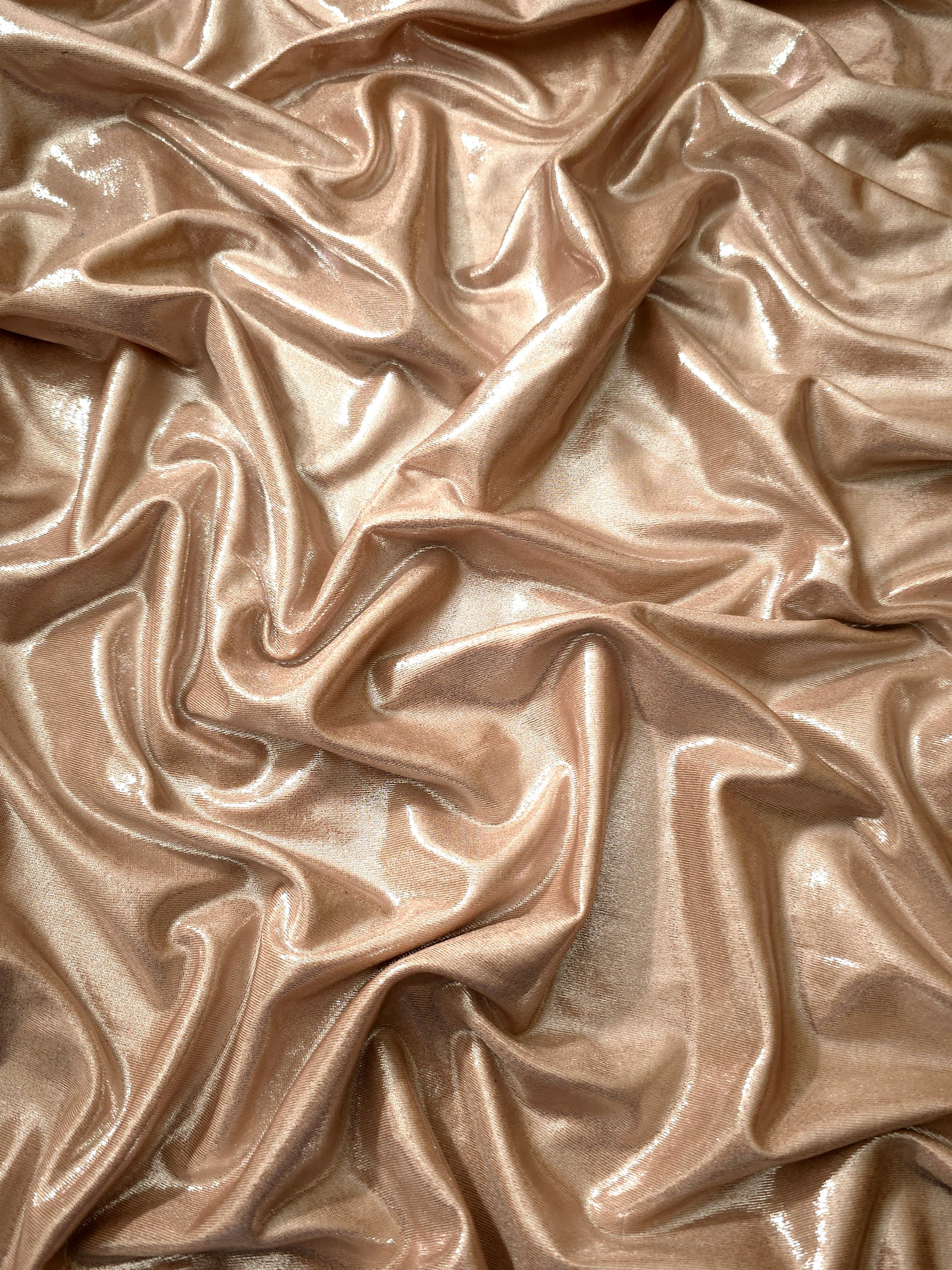 Softly draped Champagne Taupe foiled spandex fabric showing fluid shape and metallic shimmer for dresses, stage costumes and eventwear