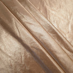 Champagne Taupe foiled spandex arranged in layered folds, displaying shimmer and soft structure for skirts, tops and performancewear