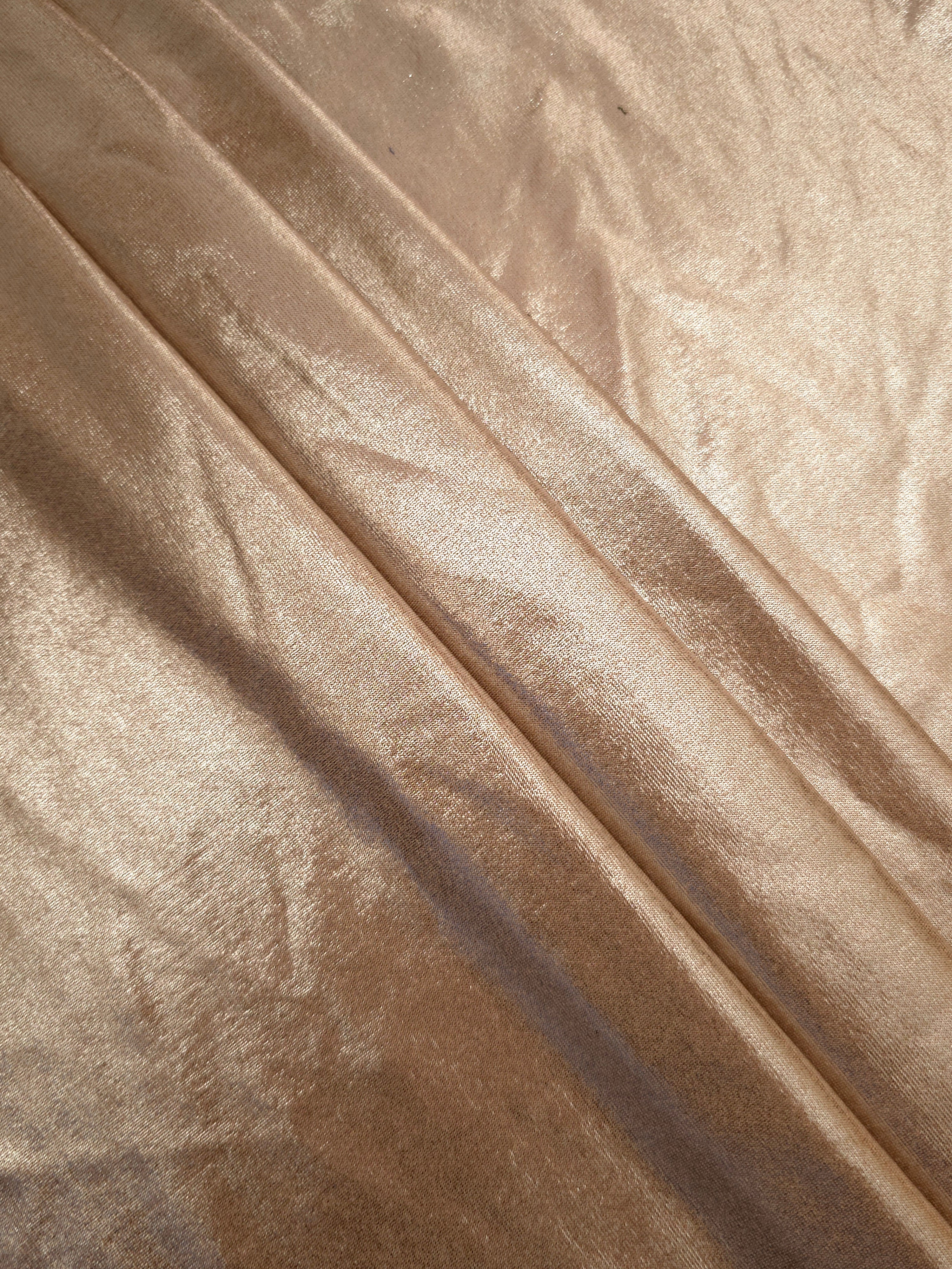 Champagne Taupe foiled spandex arranged in layered folds, displaying shimmer and soft structure for skirts, tops and performancewear