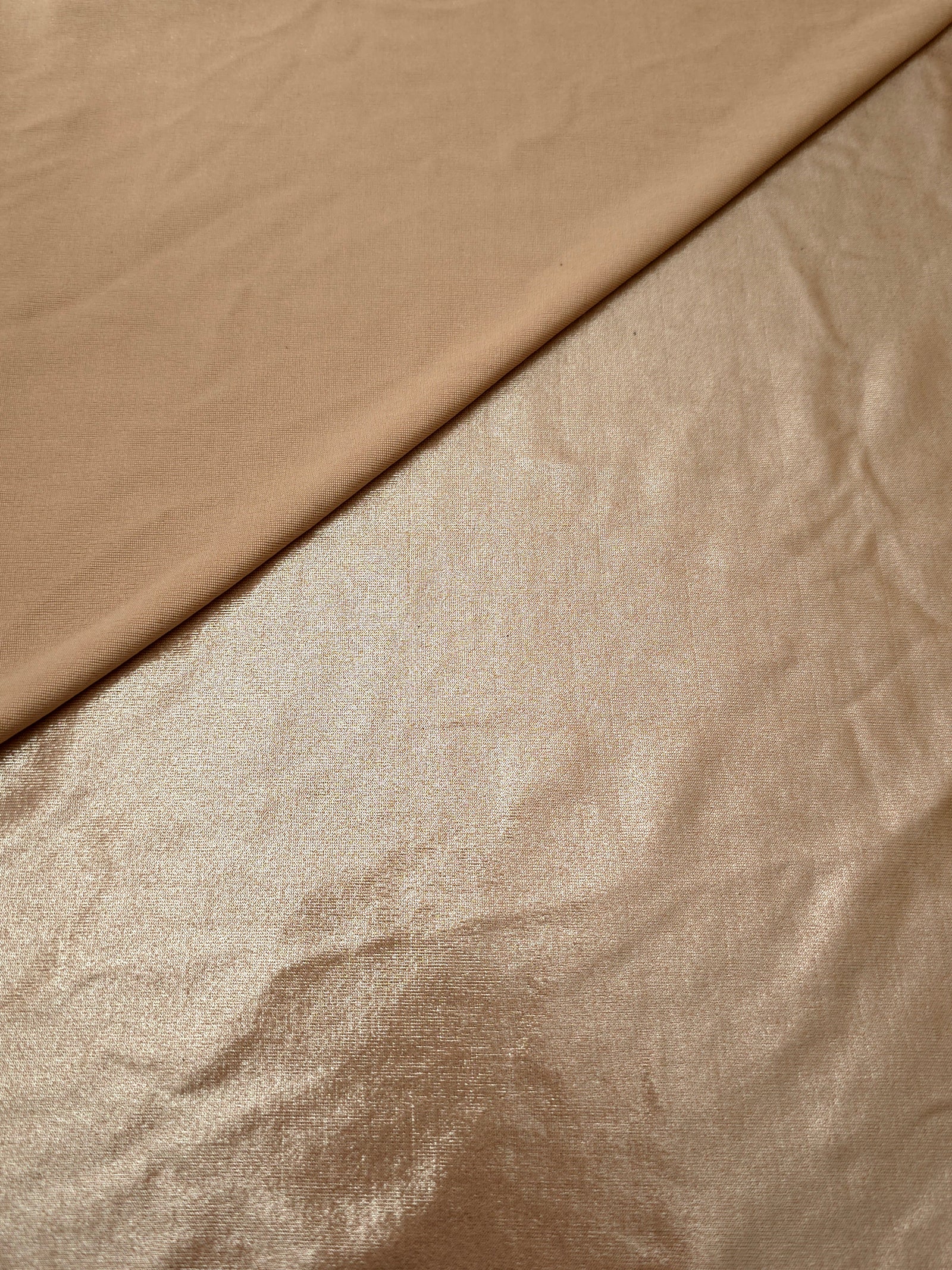 Softly folded Champagne Taupe foiled spandex showing metallic shine and flexible hand for costumes, eveningwear and creative sewing