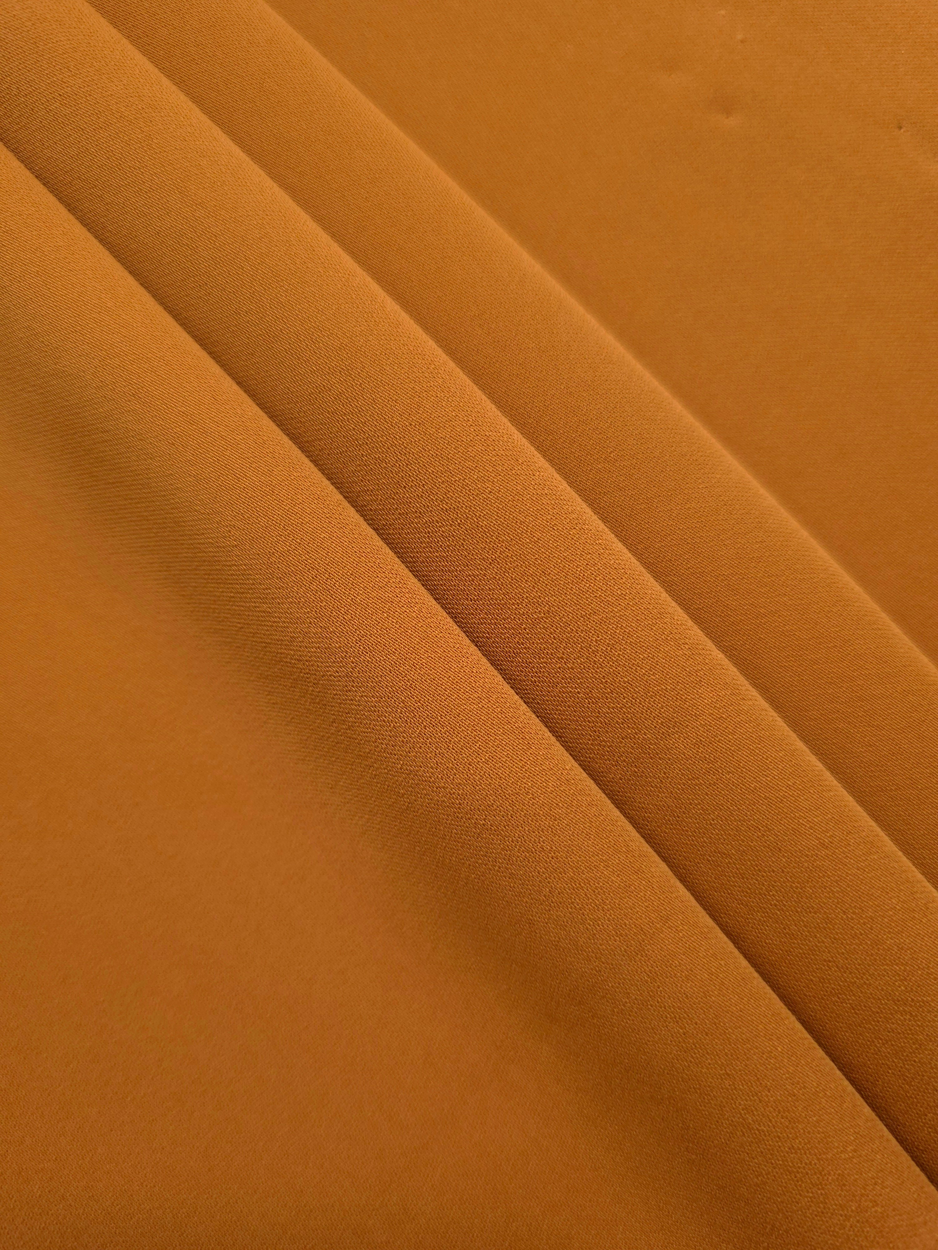 Layered Cinnamon Brown polyester crepe showing soft body and slight mechanical stretch for light tailoring