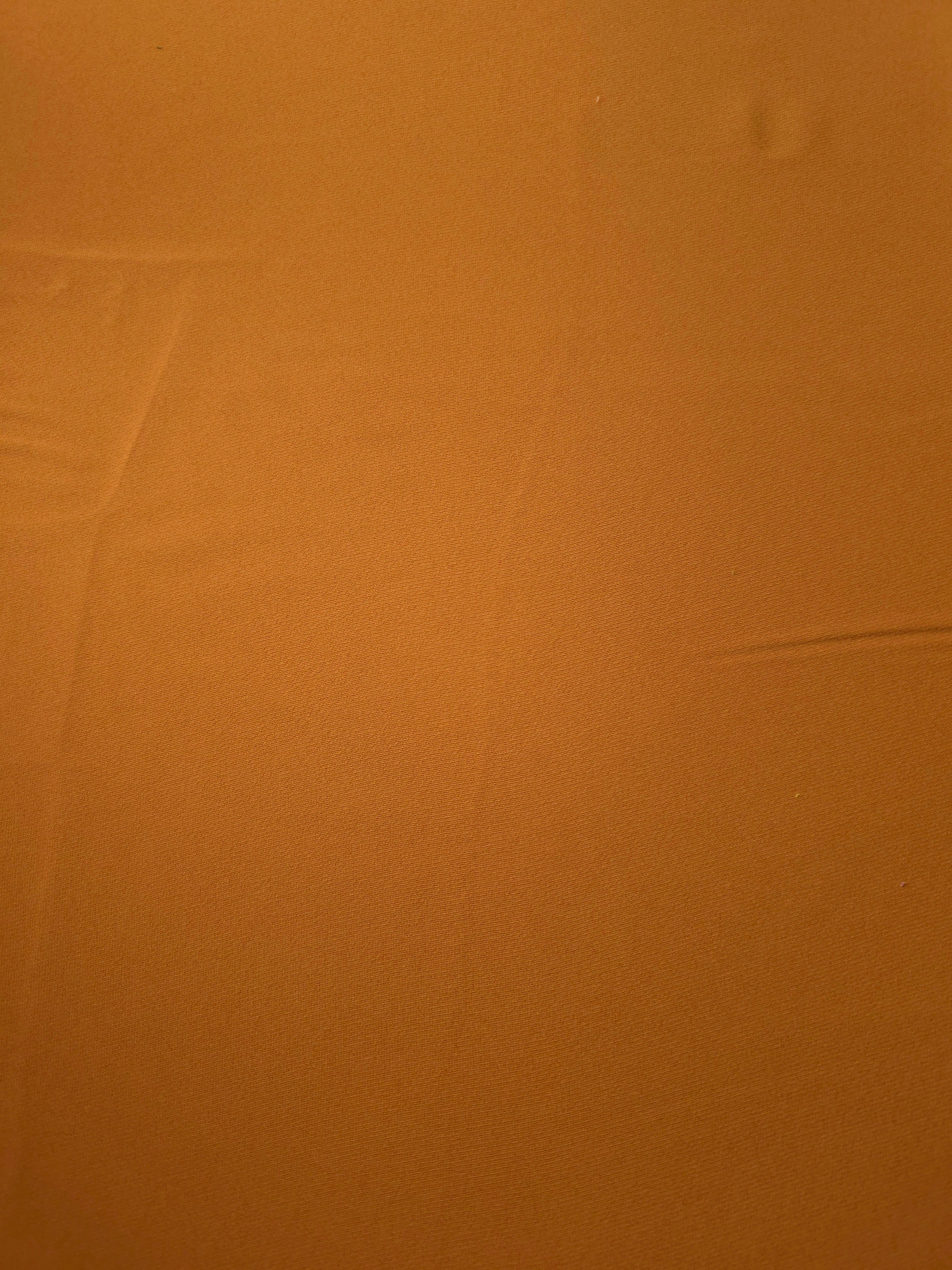 Flat surface of Cinnamon Brown Korean crepe, a 205 GSM opaque polyester fabric with smooth dressmaking character
