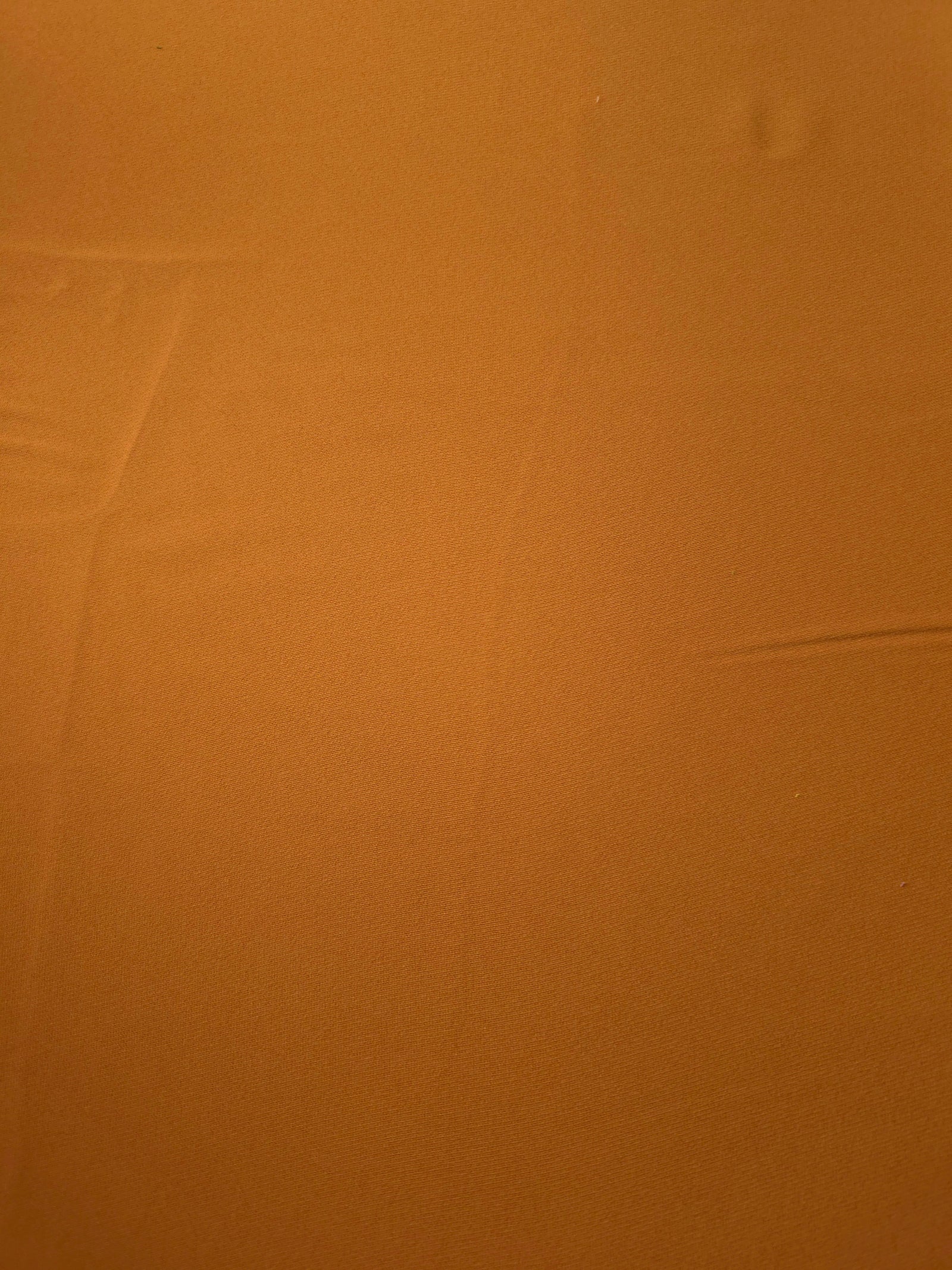 Flat surface of Cinnamon Brown Korean crepe, a 205 GSM opaque polyester fabric with smooth dressmaking character