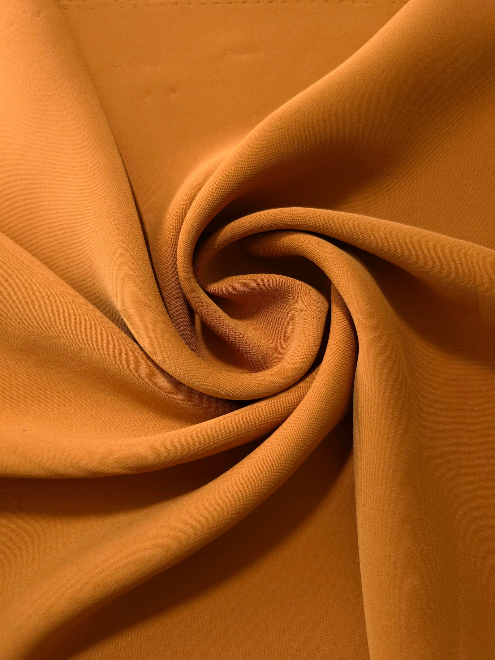 Circular drape of Cinnamon Brown polyester crepe showing flowing movement for occasion dresses and modest fashion