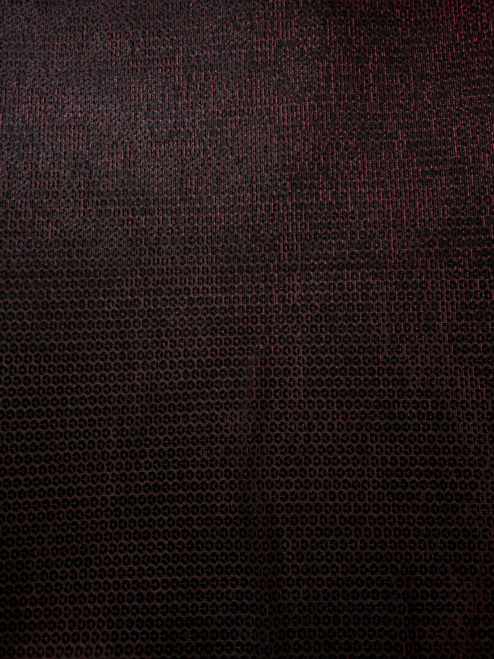 Close-up of Burgundy Red Sheer Circle Shimmer Stretch Tulle Fabric revealing the circular shimmer repeat and fine sheer mesh