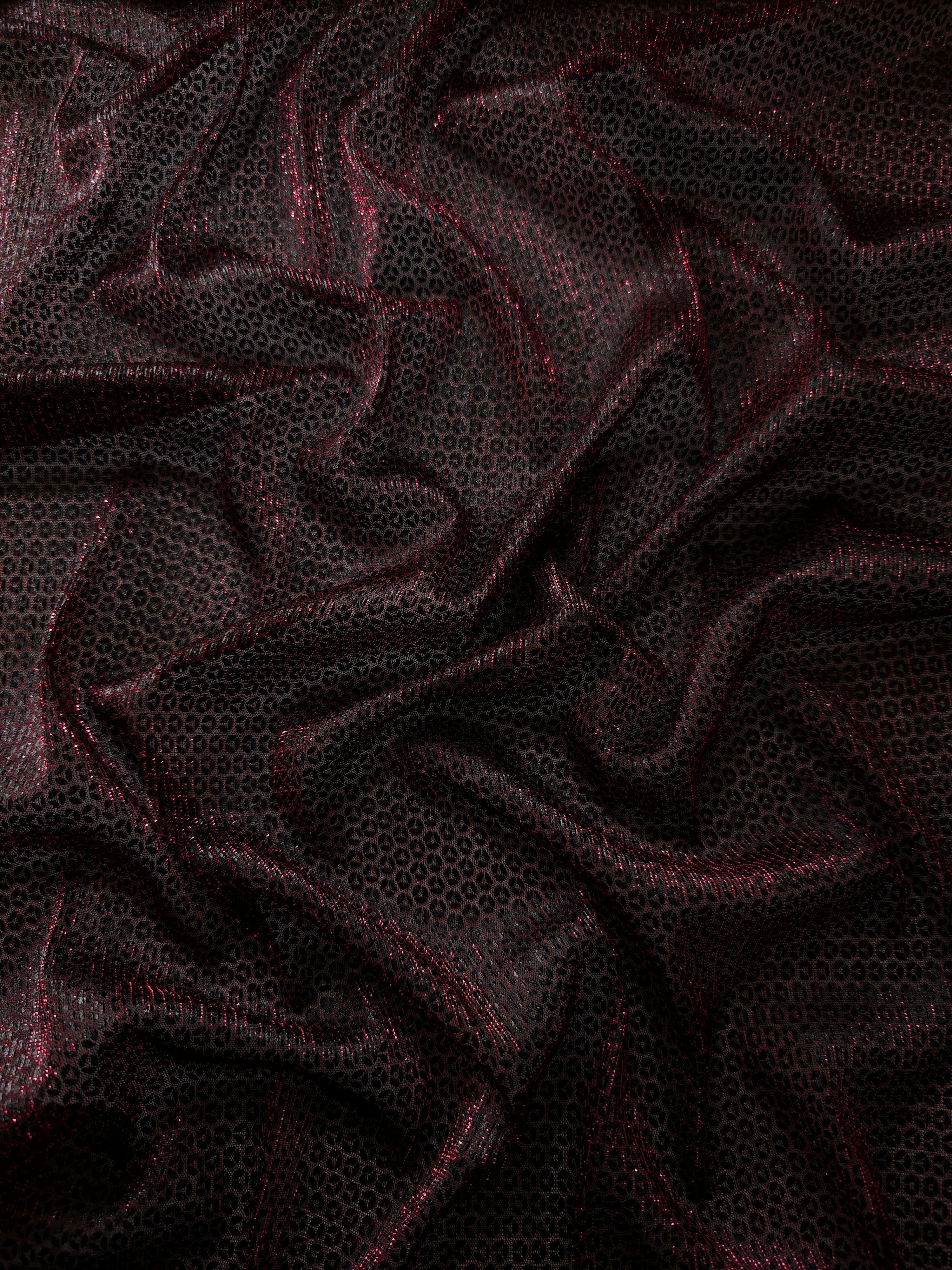 Draped Burgundy Red Sheer Circle Shimmer Stretch Tulle Fabric showing reflective round motifs across soft fluid folds