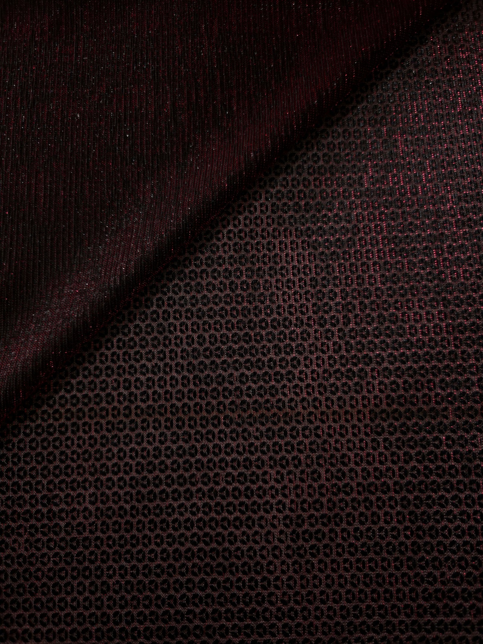 Front and back of Burgundy Red Sheer Circle Shimmer Stretch Tulle Fabric showing transparent knit structure, circle motif and stretch