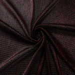Swirl-draped Burgundy Red Sheer Circle Shimmer Stretch Tulle Fabric showing circular highlights shifting through flexible movement