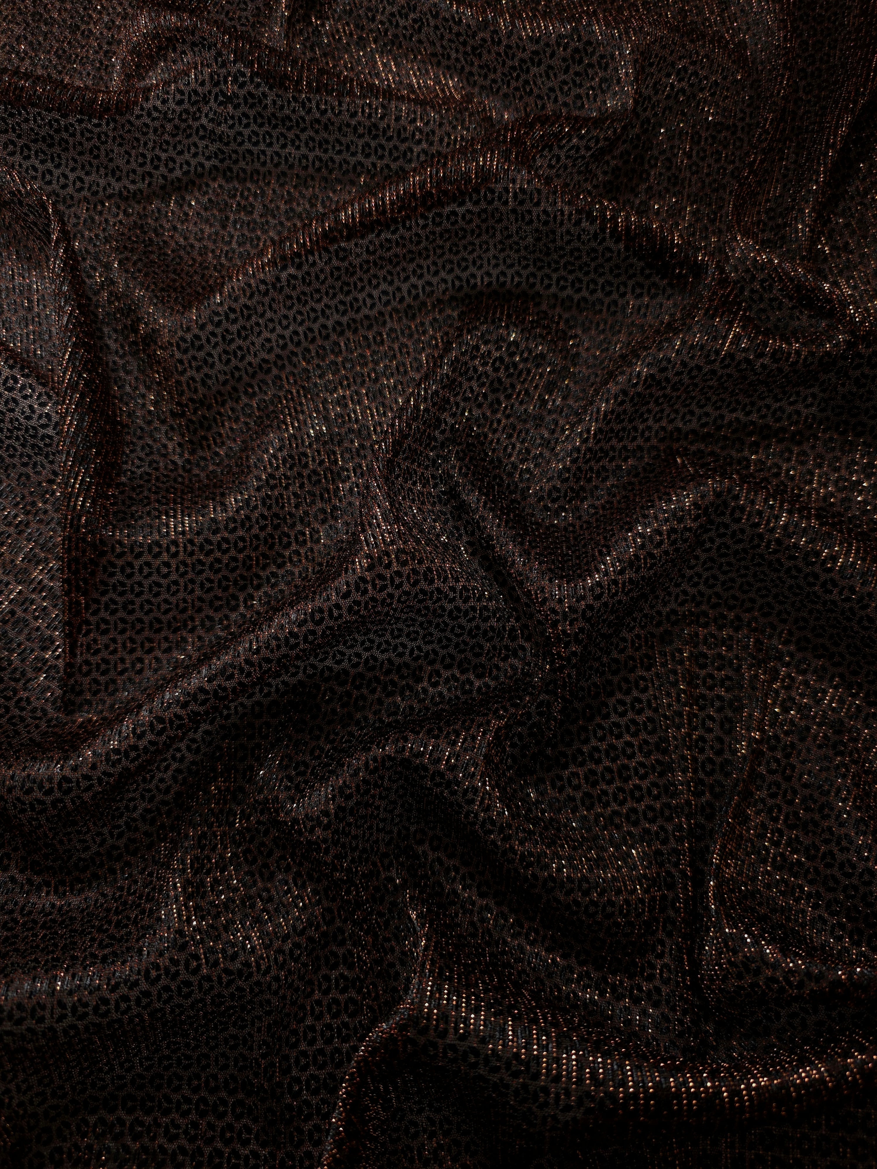 Draped Burnt Copper Sheer Circle Shimmer Stretch Tulle Fabric showing reflective round motifs across soft fluid folds