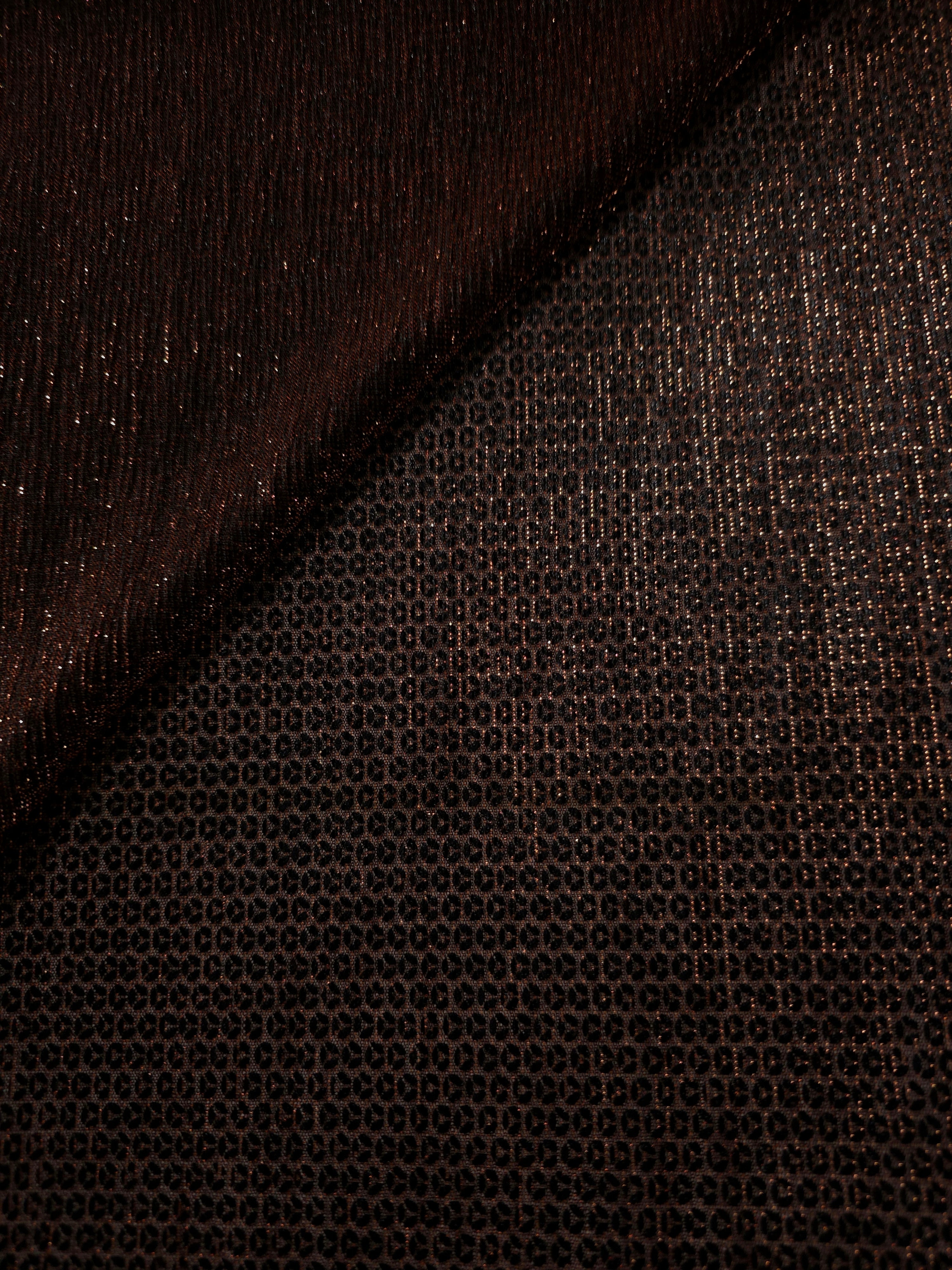 Front and back of Burnt Copper Sheer Circle Shimmer Stretch Tulle Fabric showing transparent knit structure, circle motif and stretch