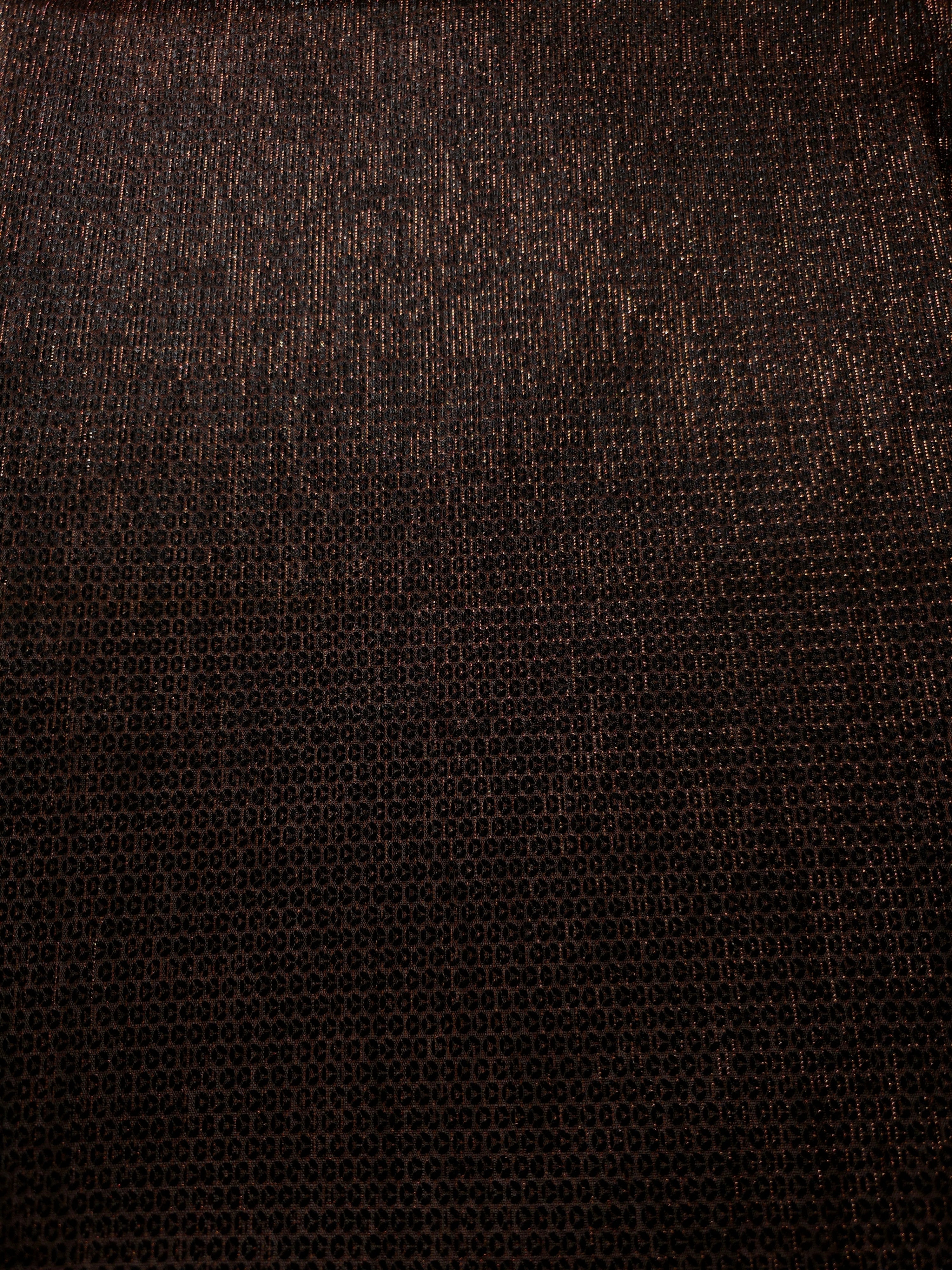 Surface detail of Burnt Copper Sheer Circle Shimmer Stretch Tulle Fabric highlighting reflective circle scale and lightweight tulle texture