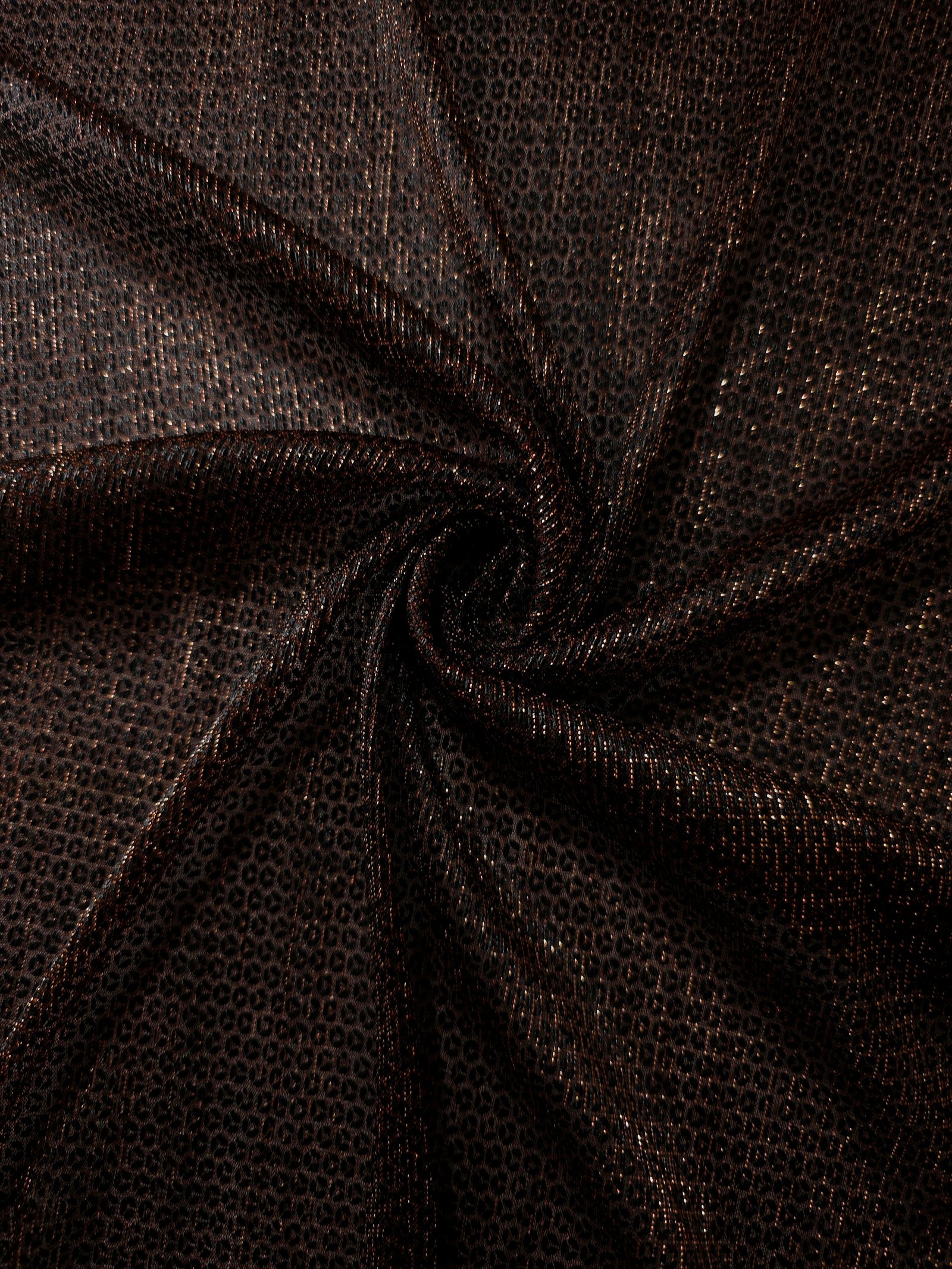 Swirl-draped Burnt Copper Sheer Circle Shimmer Stretch Tulle Fabric showing circular highlights shifting through flexible movement