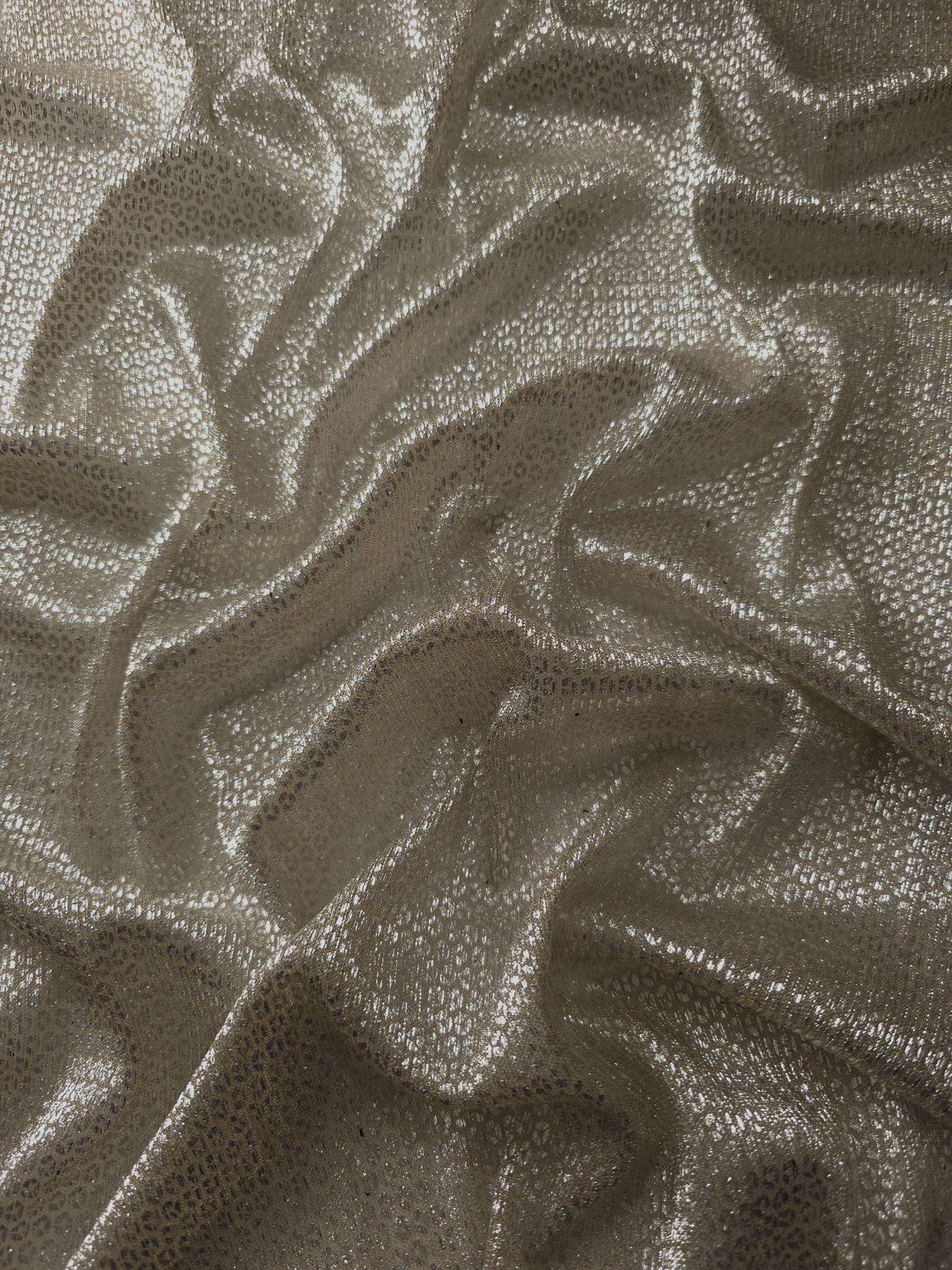 Draped Champagne Gold Sheer Circle Shimmer Stretch Tulle Fabric showing reflective round motifs across soft fluid folds