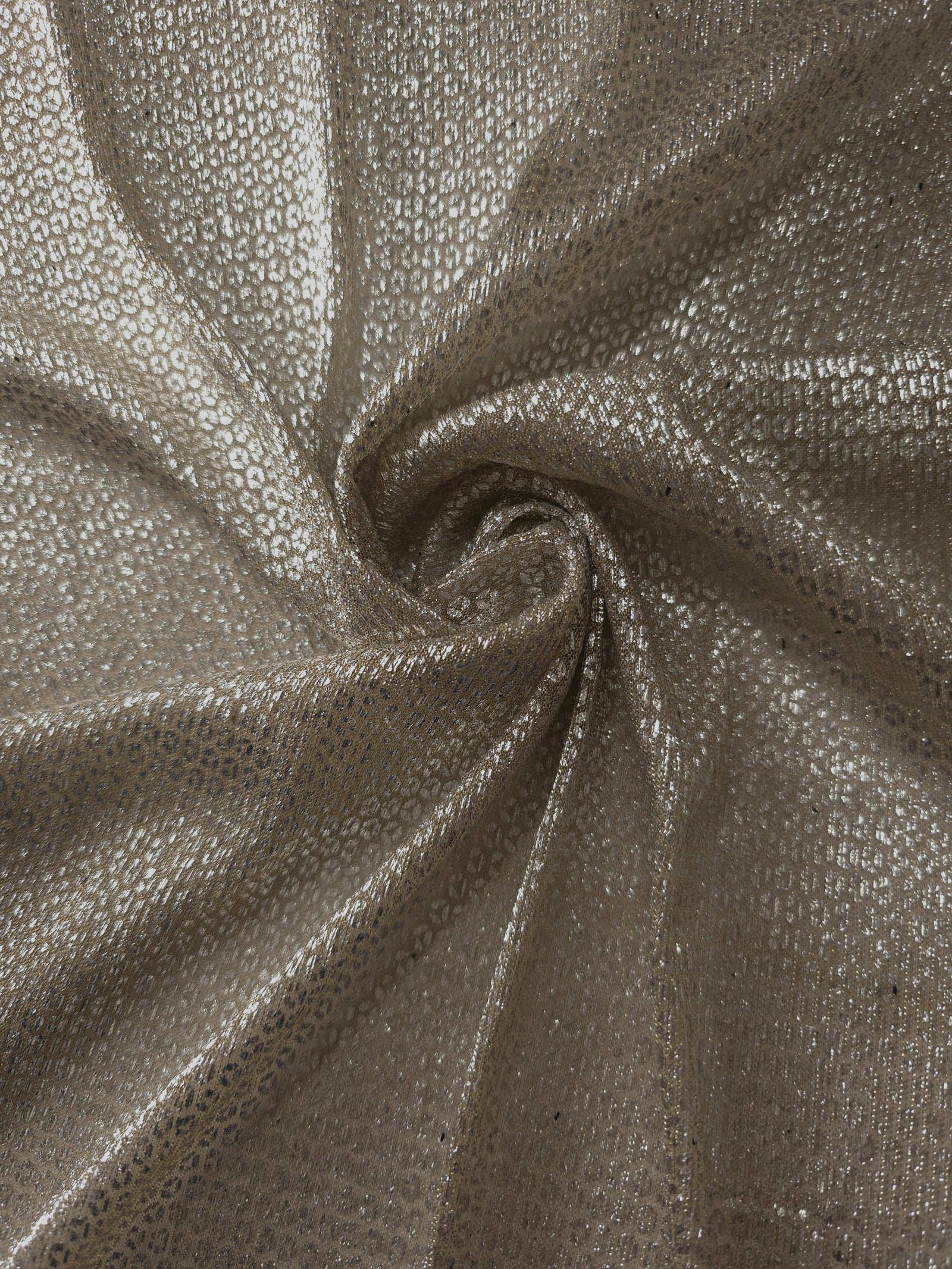 Swirl-draped Champagne Gold Sheer Circle Shimmer Stretch Tulle Fabric showing circular highlights shifting through flexible movement