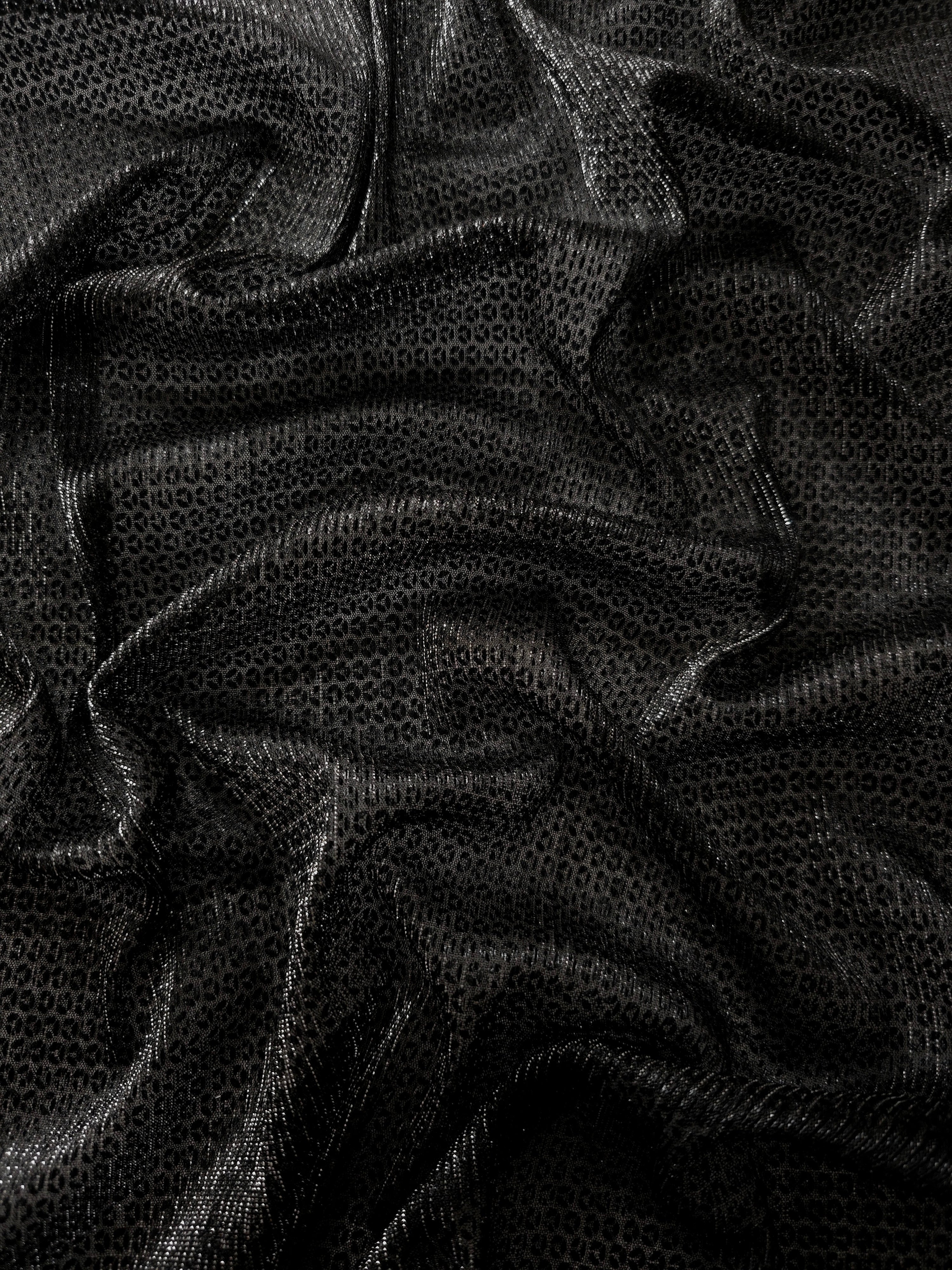 Draped Charcoal Silver Sheer Circle Shimmer Stretch Tulle Fabric showing reflective round motifs across soft fluid folds