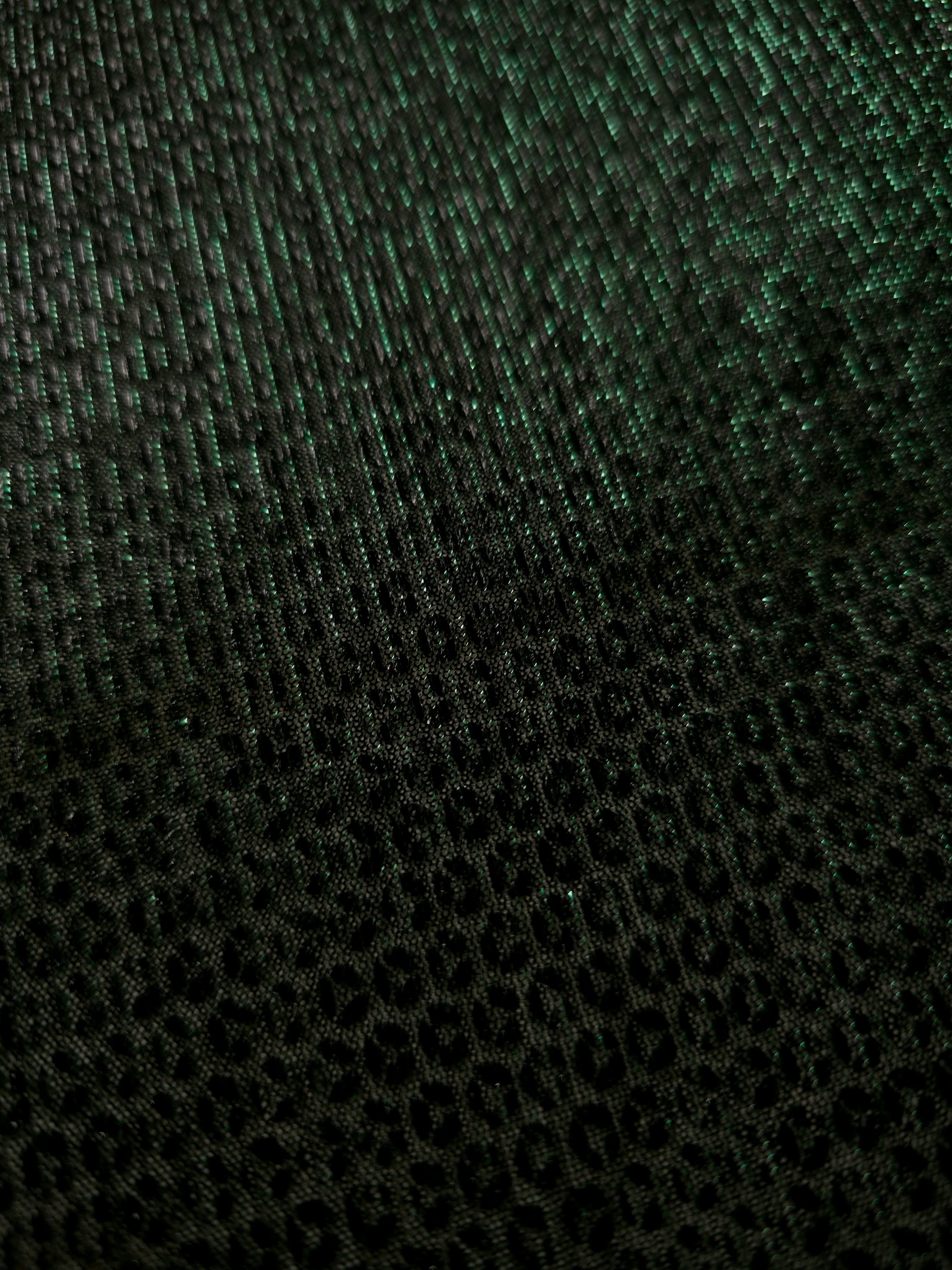 Close-up of Deep Emerald Sheer Circle Shimmer Stretch Tulle Fabric revealing the circular shimmer repeat and fine sheer mesh
