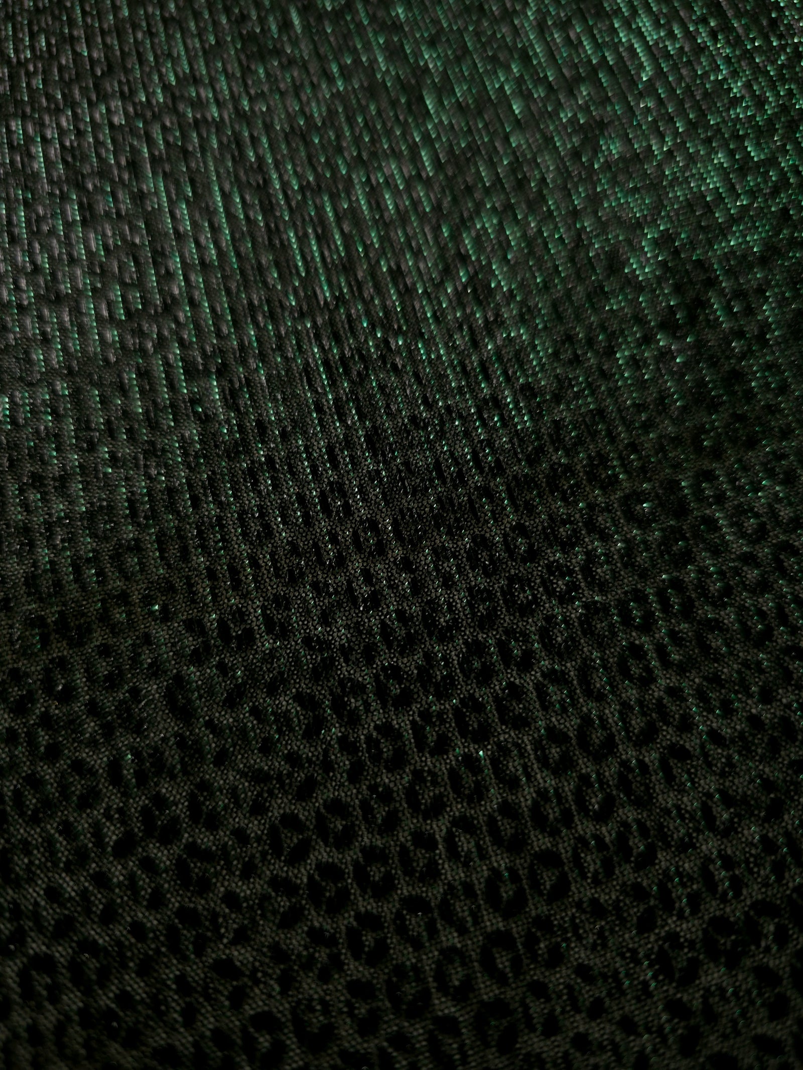 Close-up of Deep Emerald Sheer Circle Shimmer Stretch Tulle Fabric revealing the circular shimmer repeat and fine sheer mesh