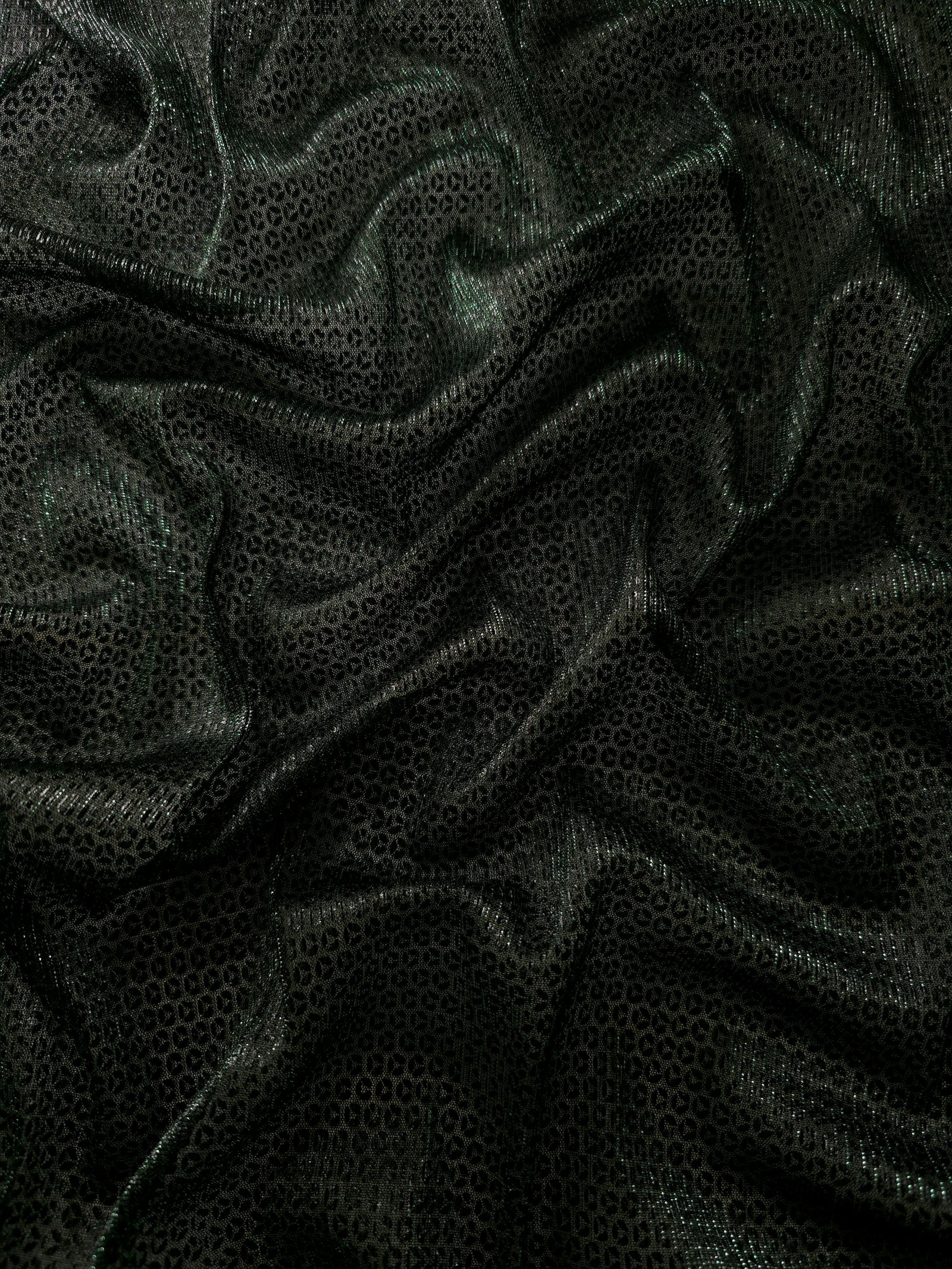 Draped Deep Emerald Sheer Circle Shimmer Stretch Tulle Fabric showing reflective round motifs across soft fluid folds