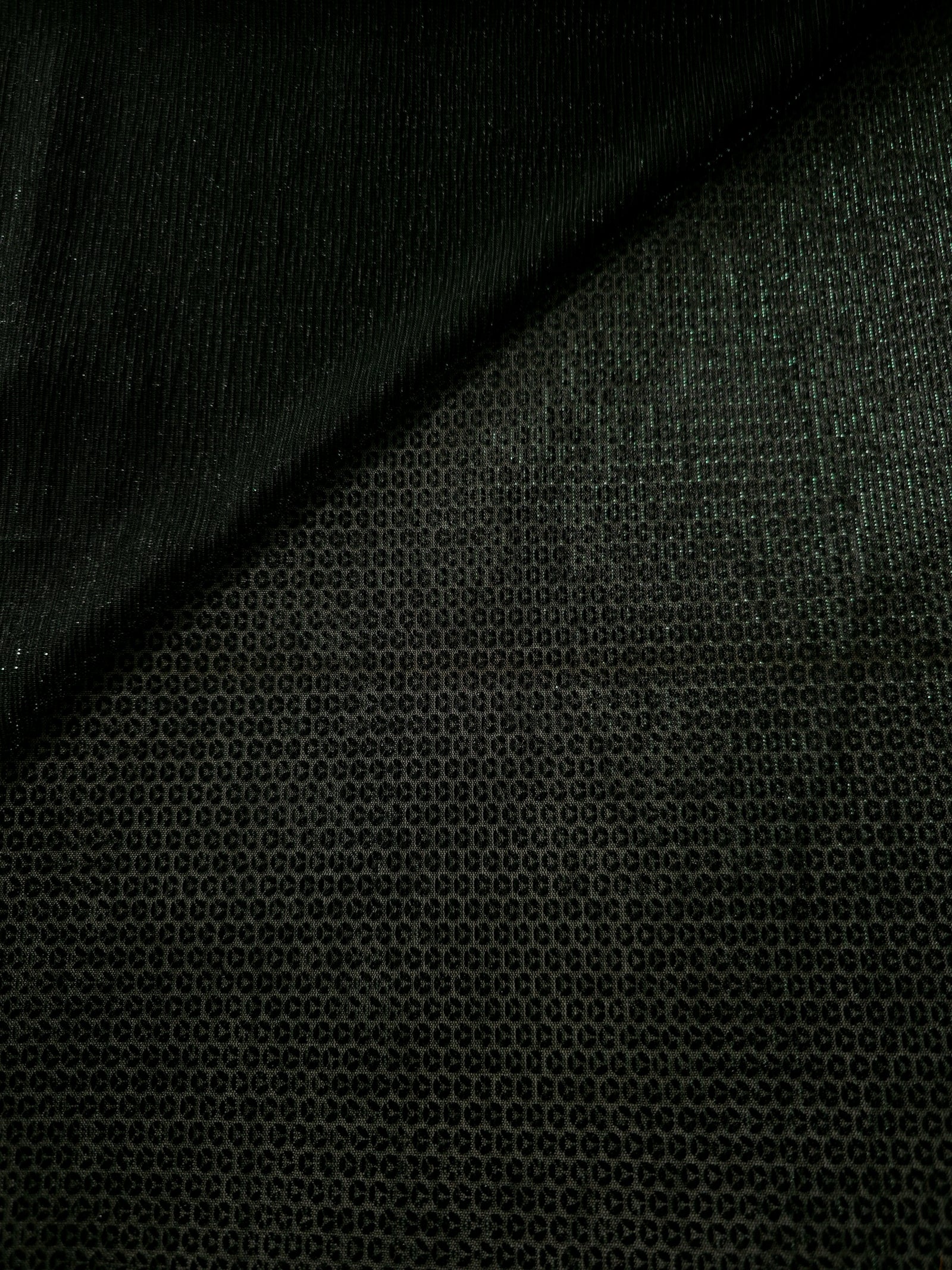 Front and back of Deep Emerald Sheer Circle Shimmer Stretch Tulle Fabric showing transparent knit structure, circle motif and stretch