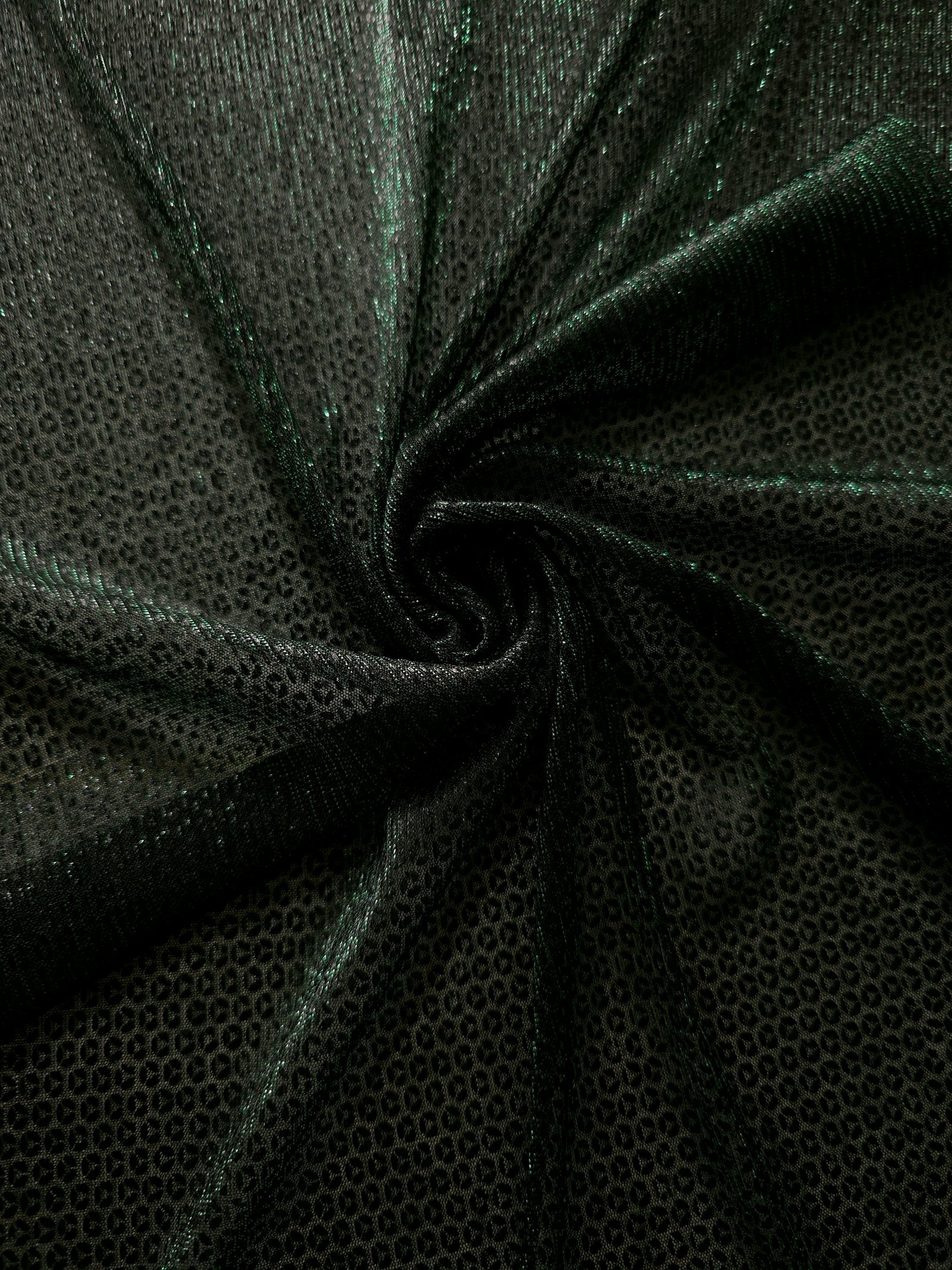 Swirl-draped Deep Emerald Sheer Circle Shimmer Stretch Tulle Fabric showing circular highlights shifting through flexible movement