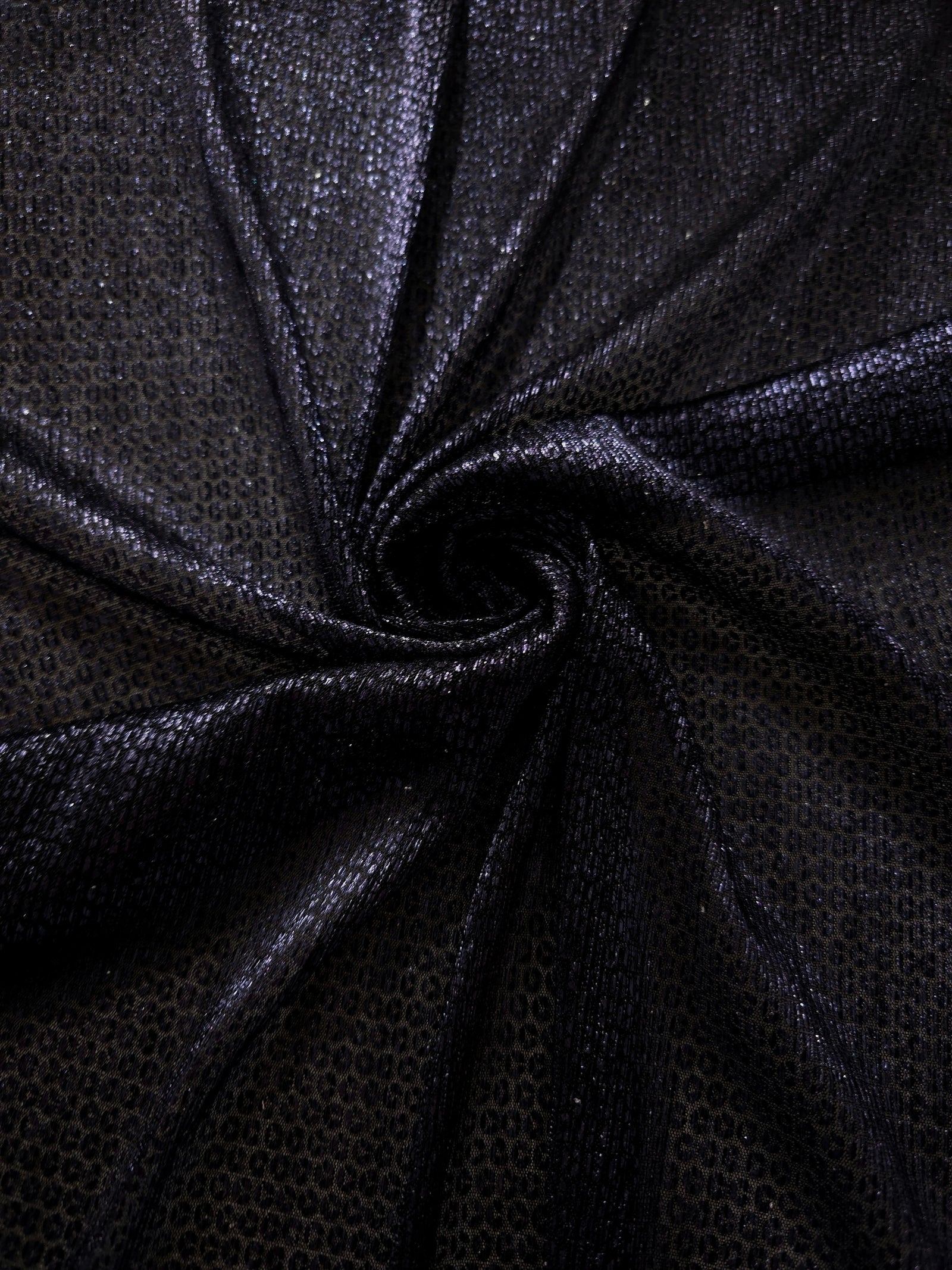 Draped Midnight Indigo Sheer Circle Shimmer Stretch Tulle Fabric showing reflective round motifs across soft fluid folds