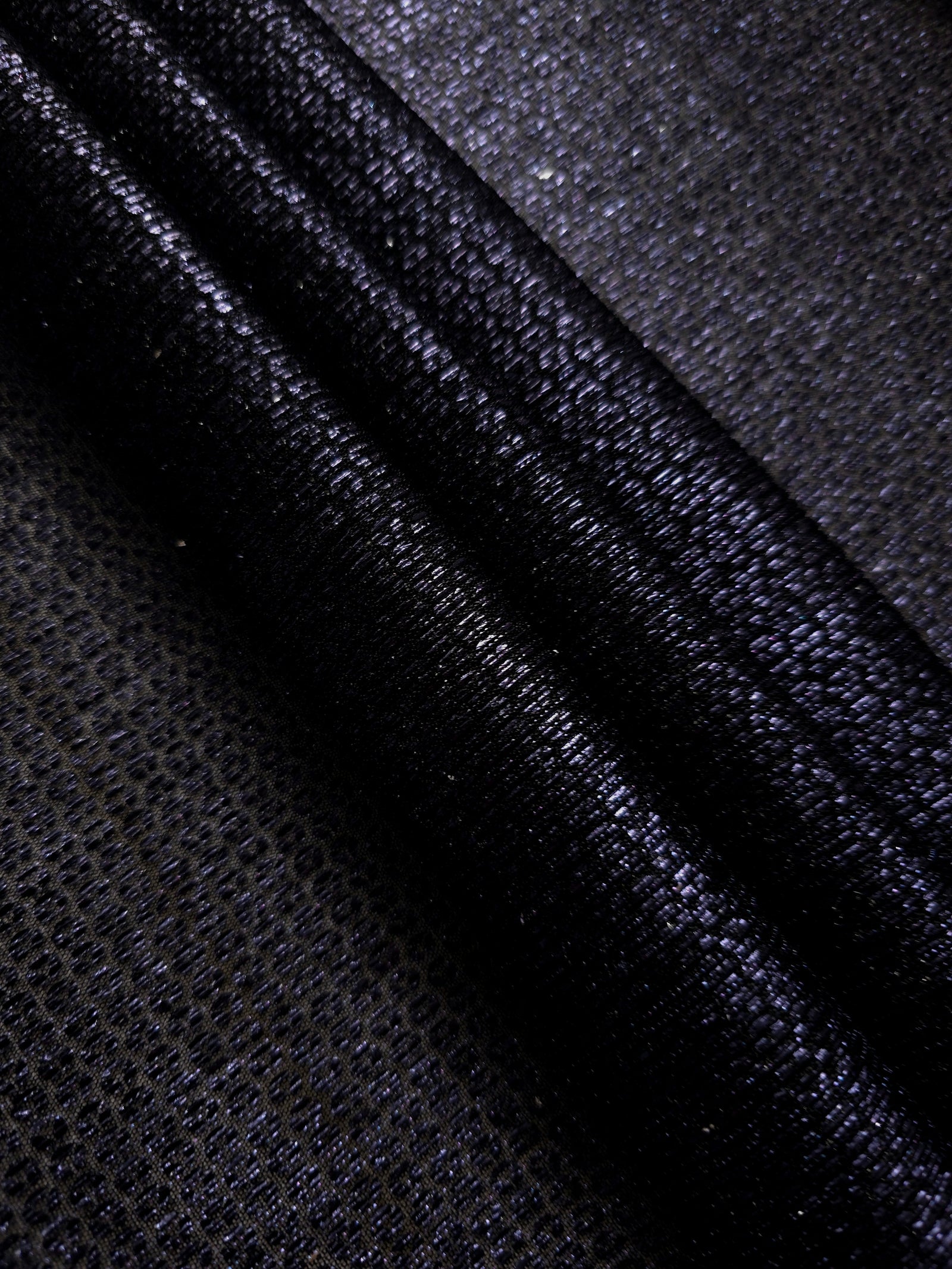 Swirl-draped Midnight Indigo Sheer Circle Shimmer Stretch Tulle Fabric showing circular highlights shifting through flexible movement