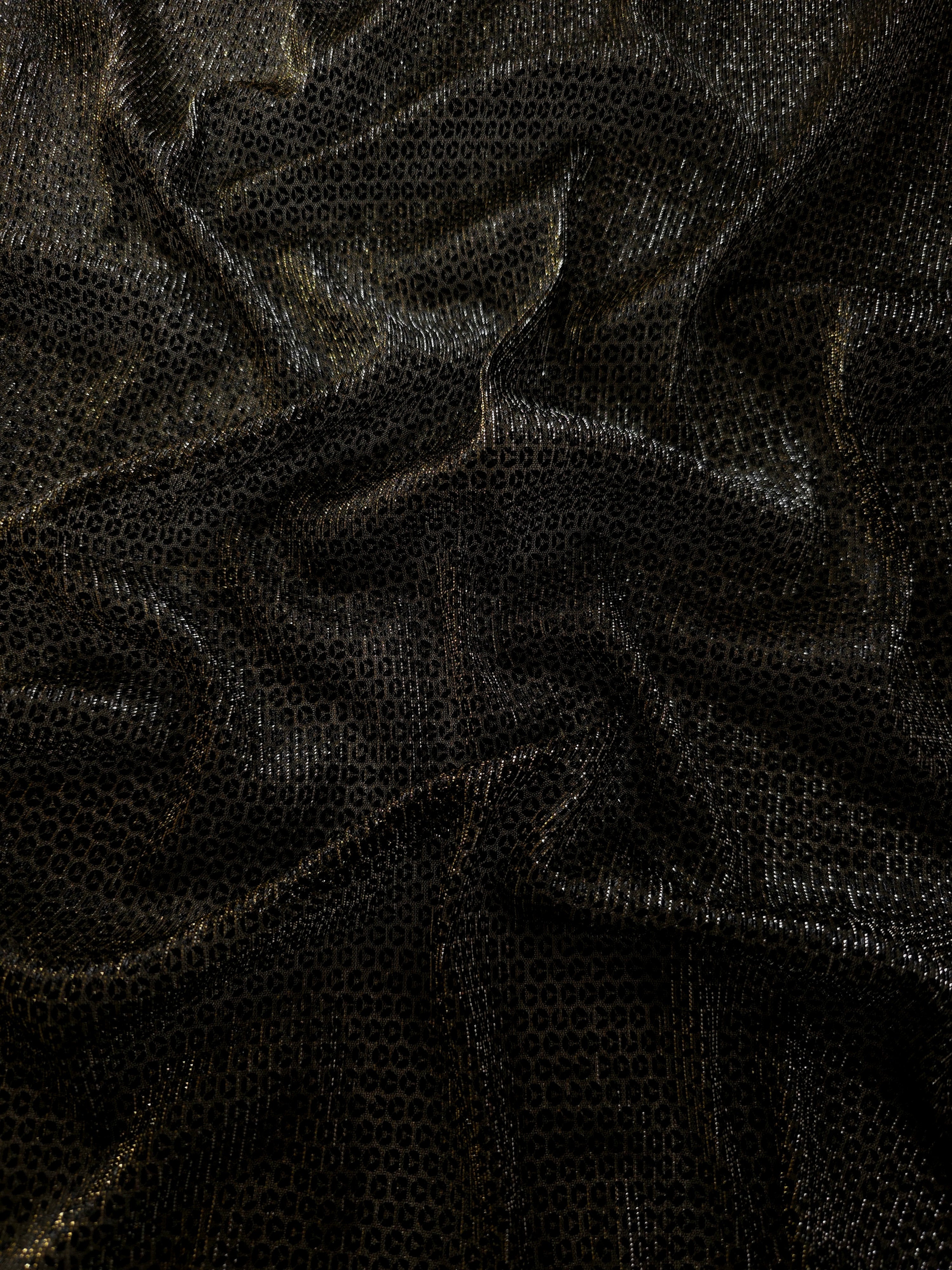 Draped Olive Gold Sheer Circle Shimmer Stretch Tulle Fabric showing reflective round motifs across soft fluid folds