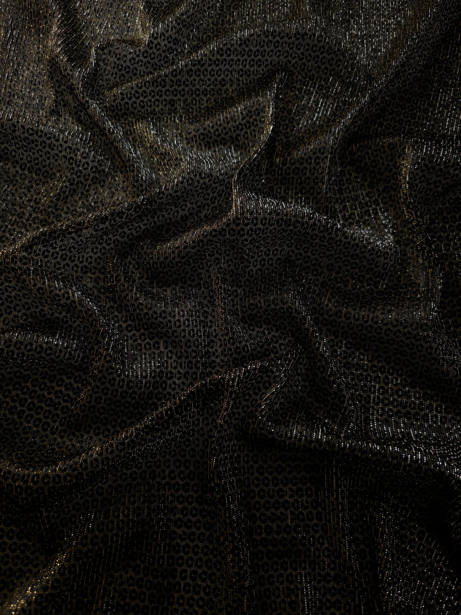 Draped Olive Gold Sheer Circle Shimmer Stretch Tulle Fabric showing reflective round motifs across soft fluid folds