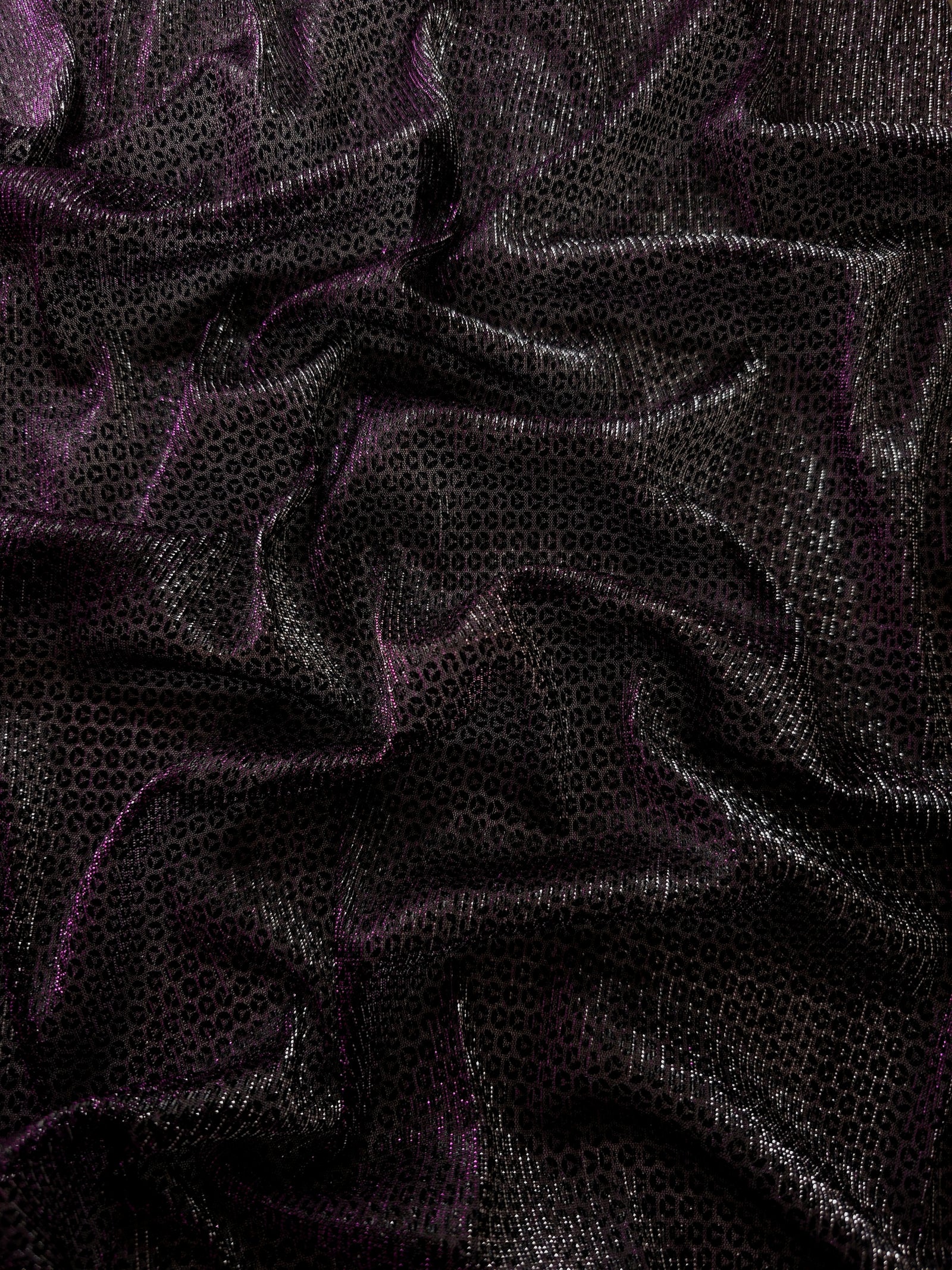 Draped Plum Violet Sheer Circle Shimmer Stretch Tulle Fabric showing reflective round motifs across soft fluid folds