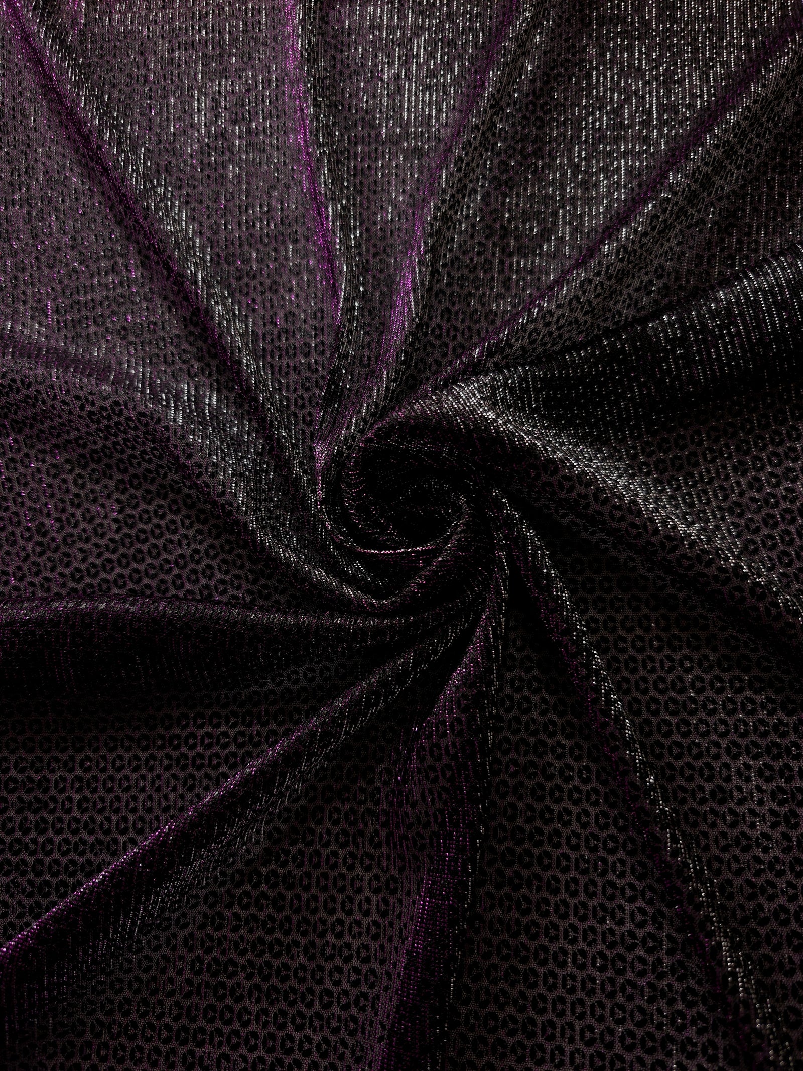 Swirl-draped Plum Violet Sheer Circle Shimmer Stretch Tulle Fabric showing circular highlights shifting through flexible movement