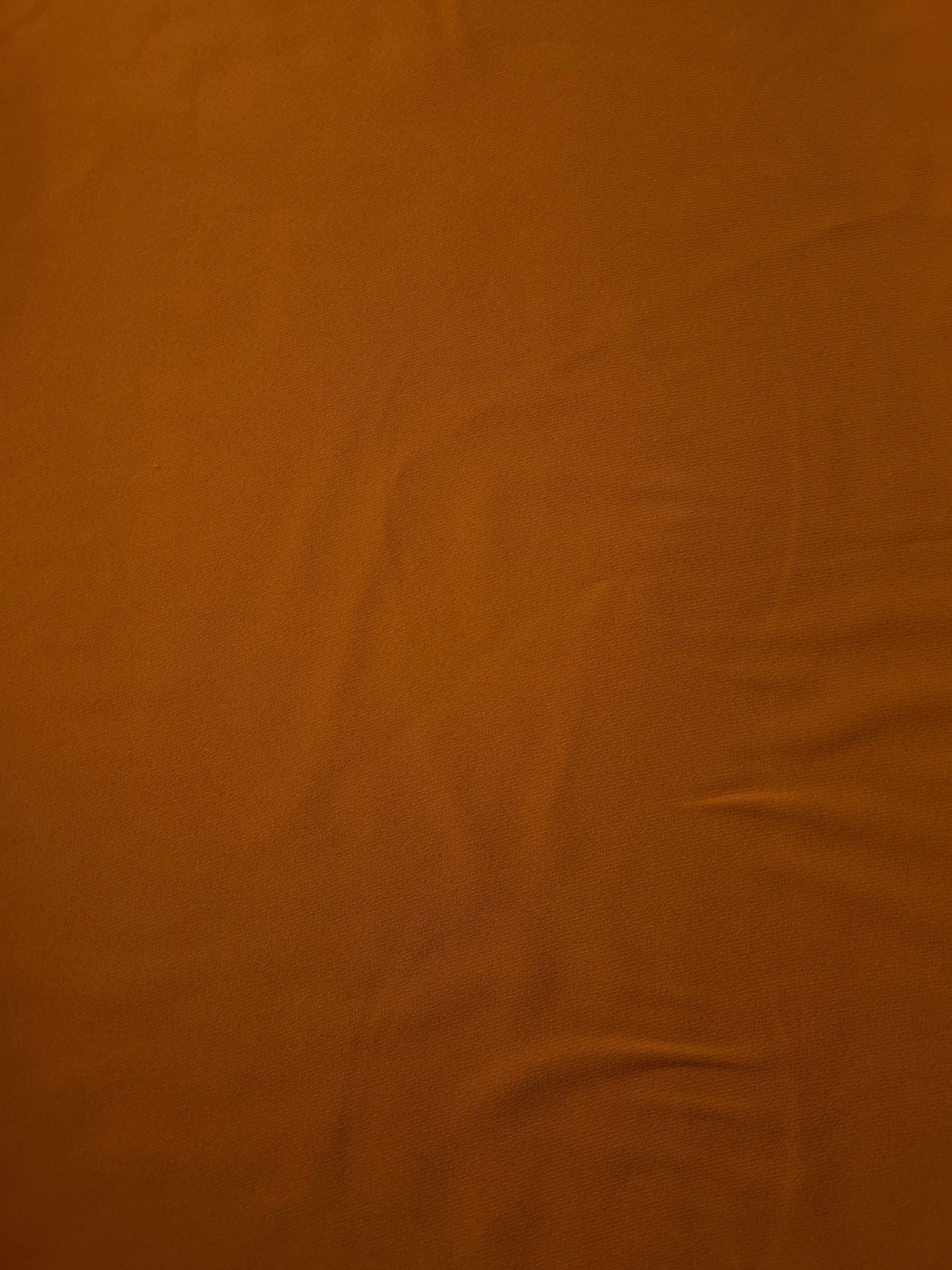 Cognac Brown Italian polyester crepe shown flat, smooth apparel fabric with a soft silky-feel finish