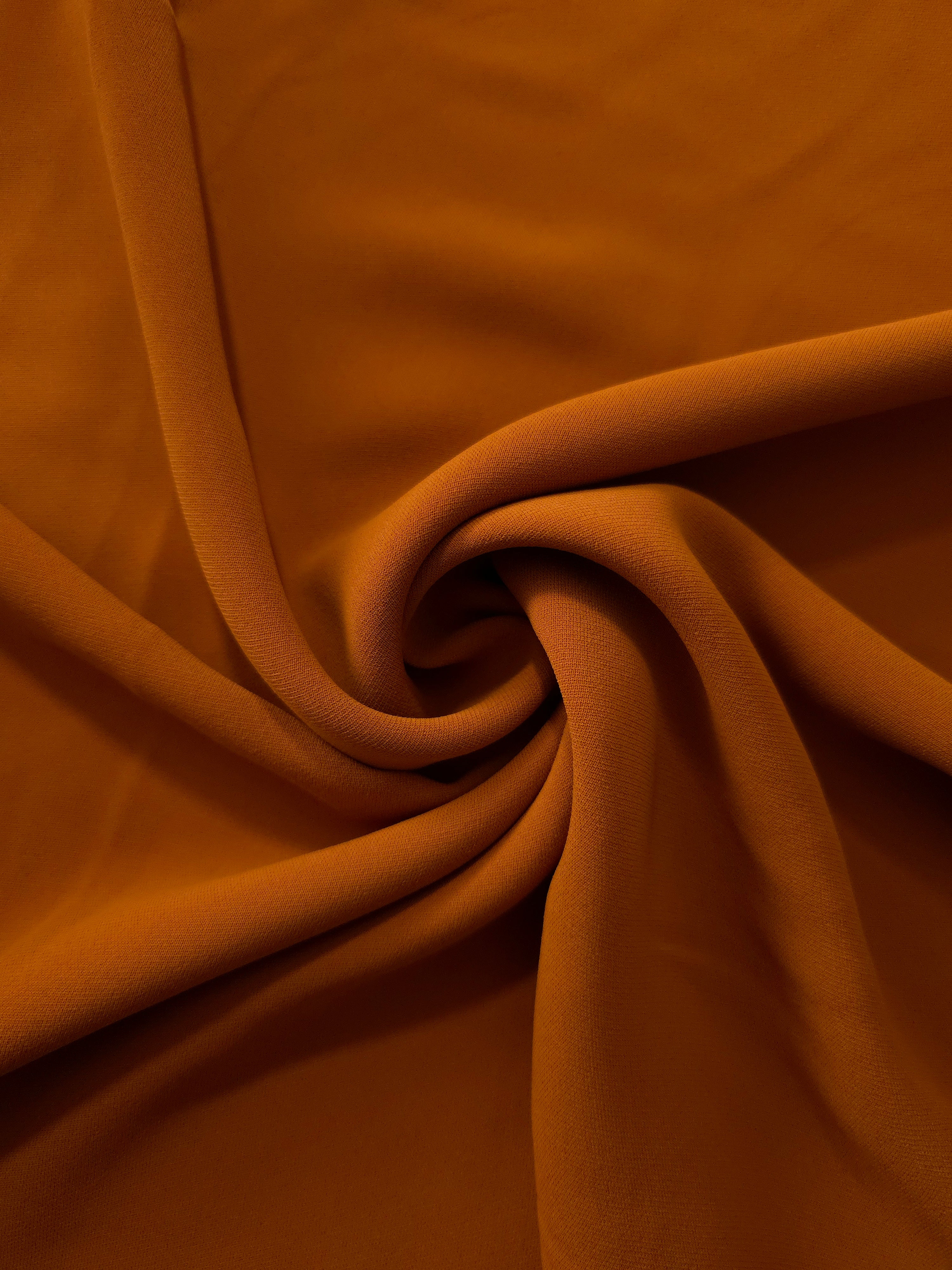 Cognac Brown silky-feel polyester crepe in a flowing swirl, showing drape for abayas and modest fashion