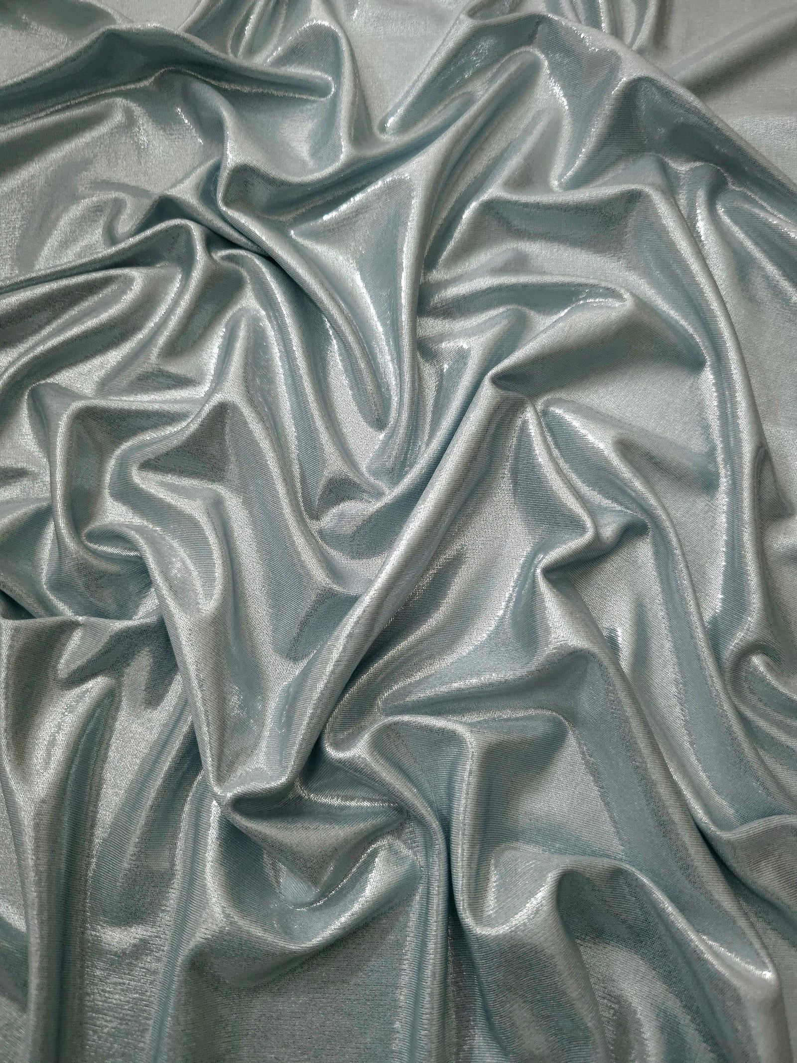 Cool Silver Gray metallic stretch fabric arranged in elegant folds, showing reflective movement for occasionwear, costumes and fashion design