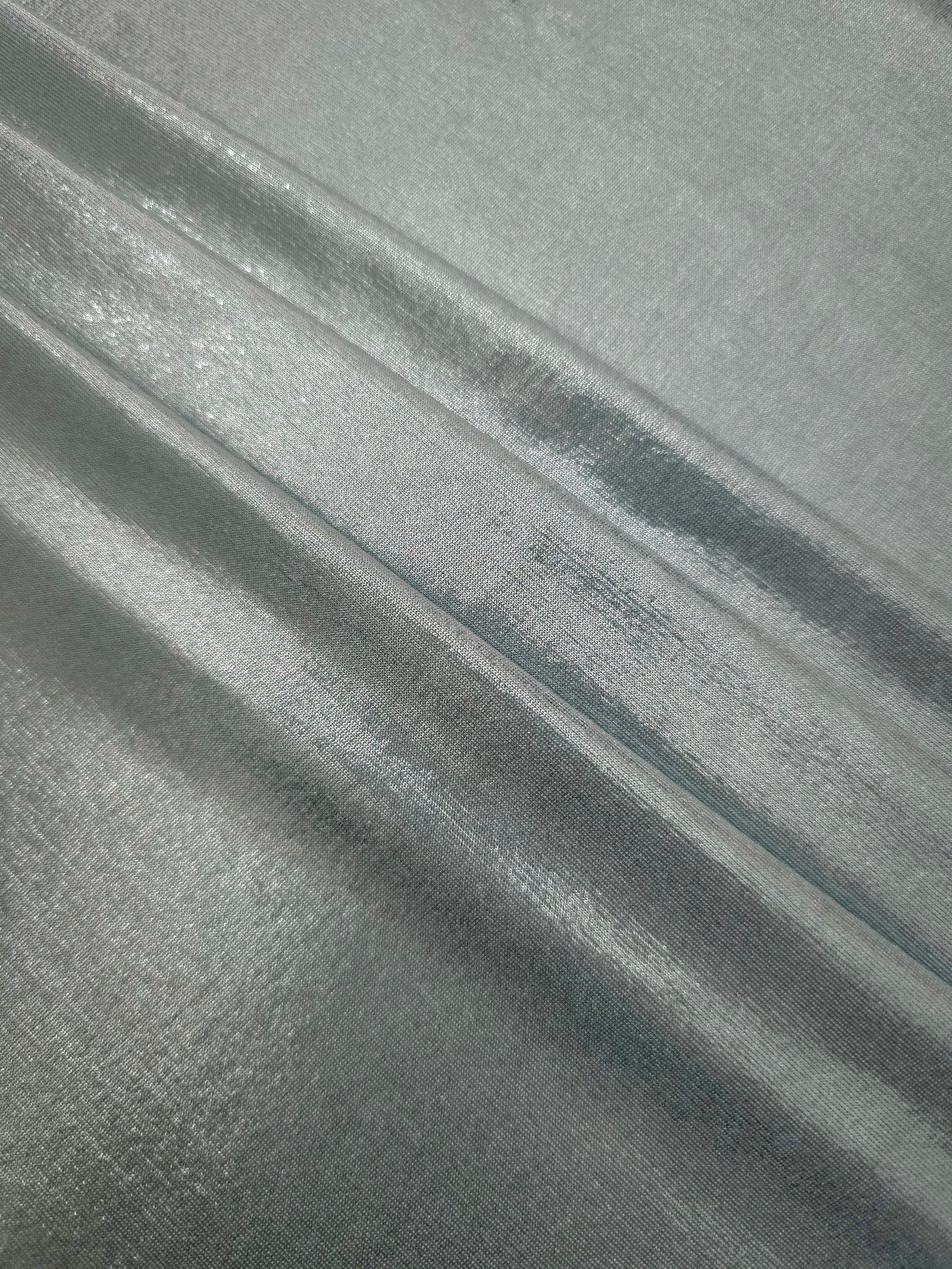Layered Cool Silver Gray metallic stretch fabric with reflective foil finish, showing flexible body for dancewear and occasion fashion
