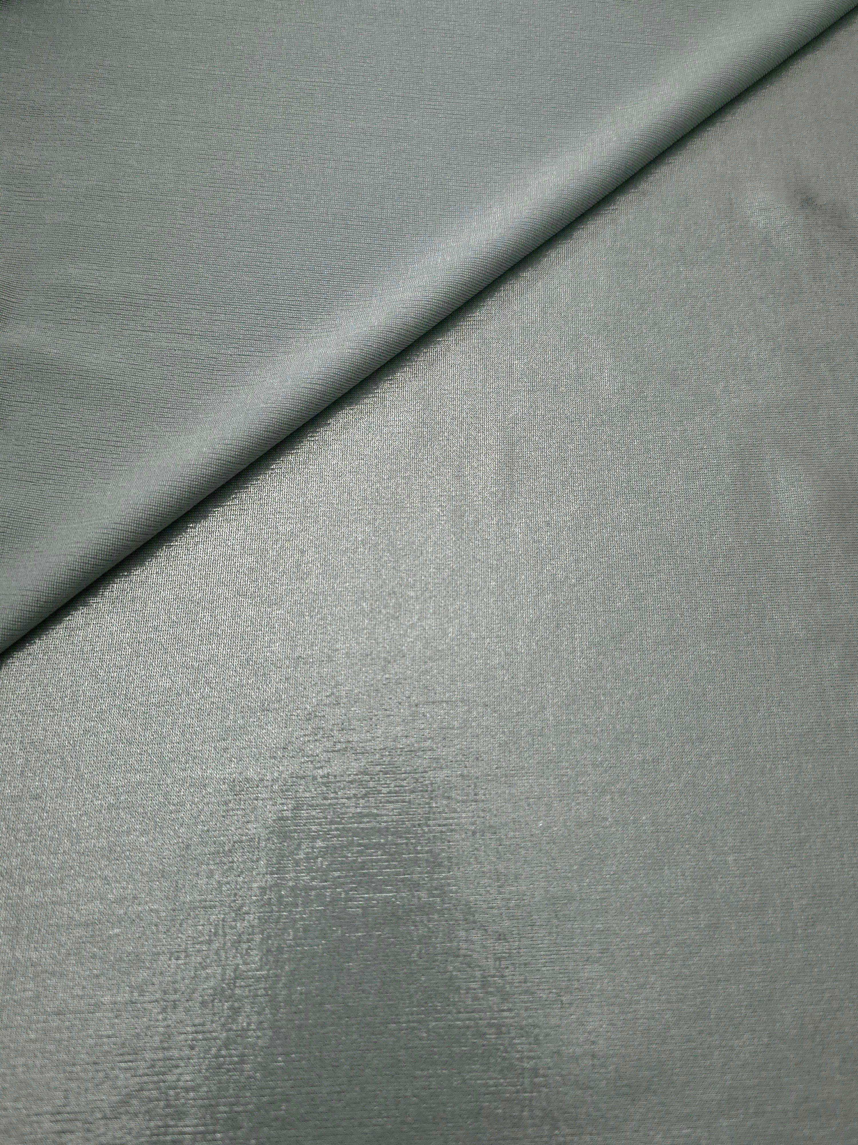 Cool Silver Gray metallic stretch fabric in a soft fold, revealing reflective drape for dancewear, dresses and statement apparel