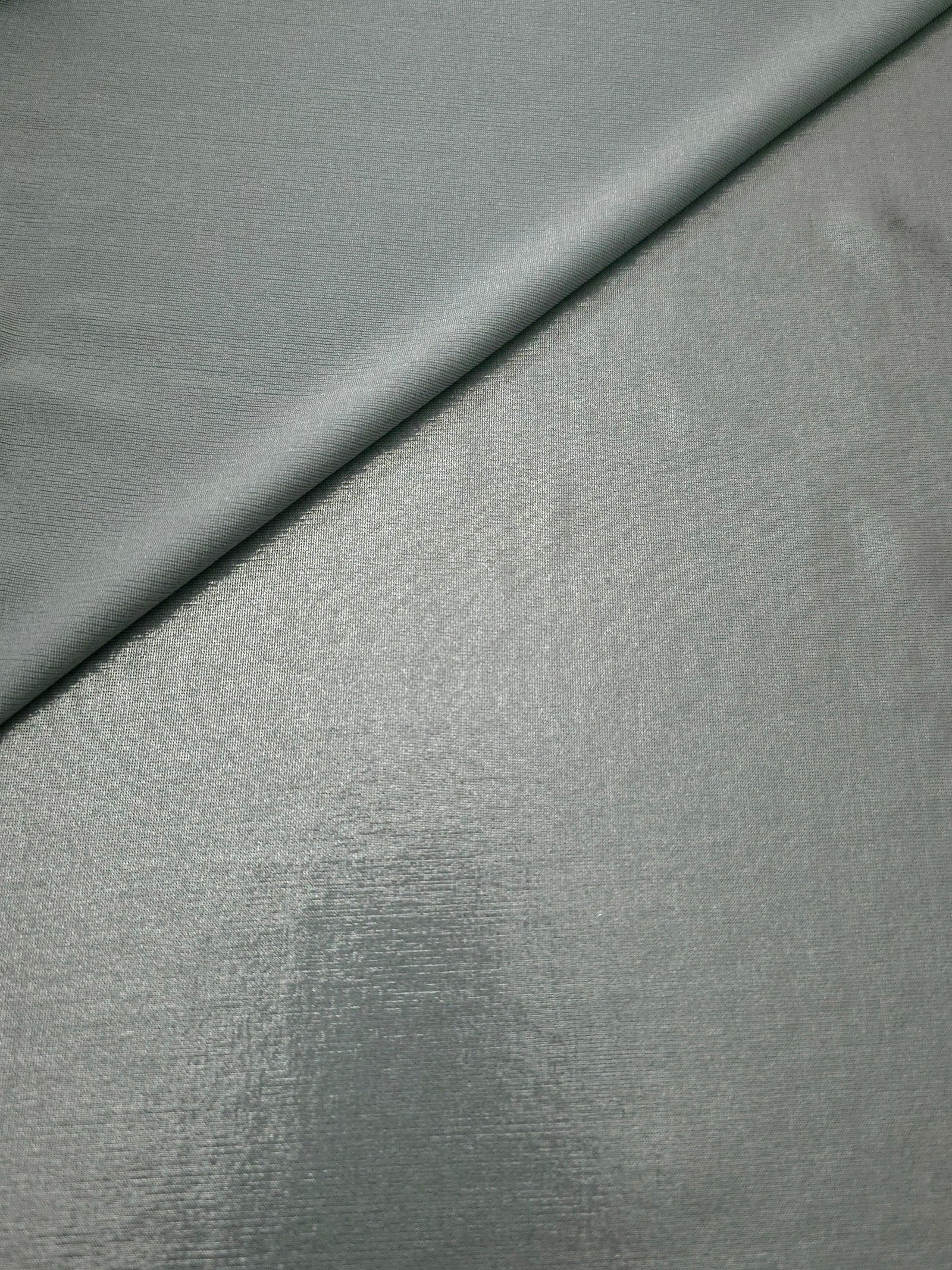 Cool Silver Gray metallic stretch fabric in a soft fold, revealing reflective drape for dancewear, dresses and statement apparel