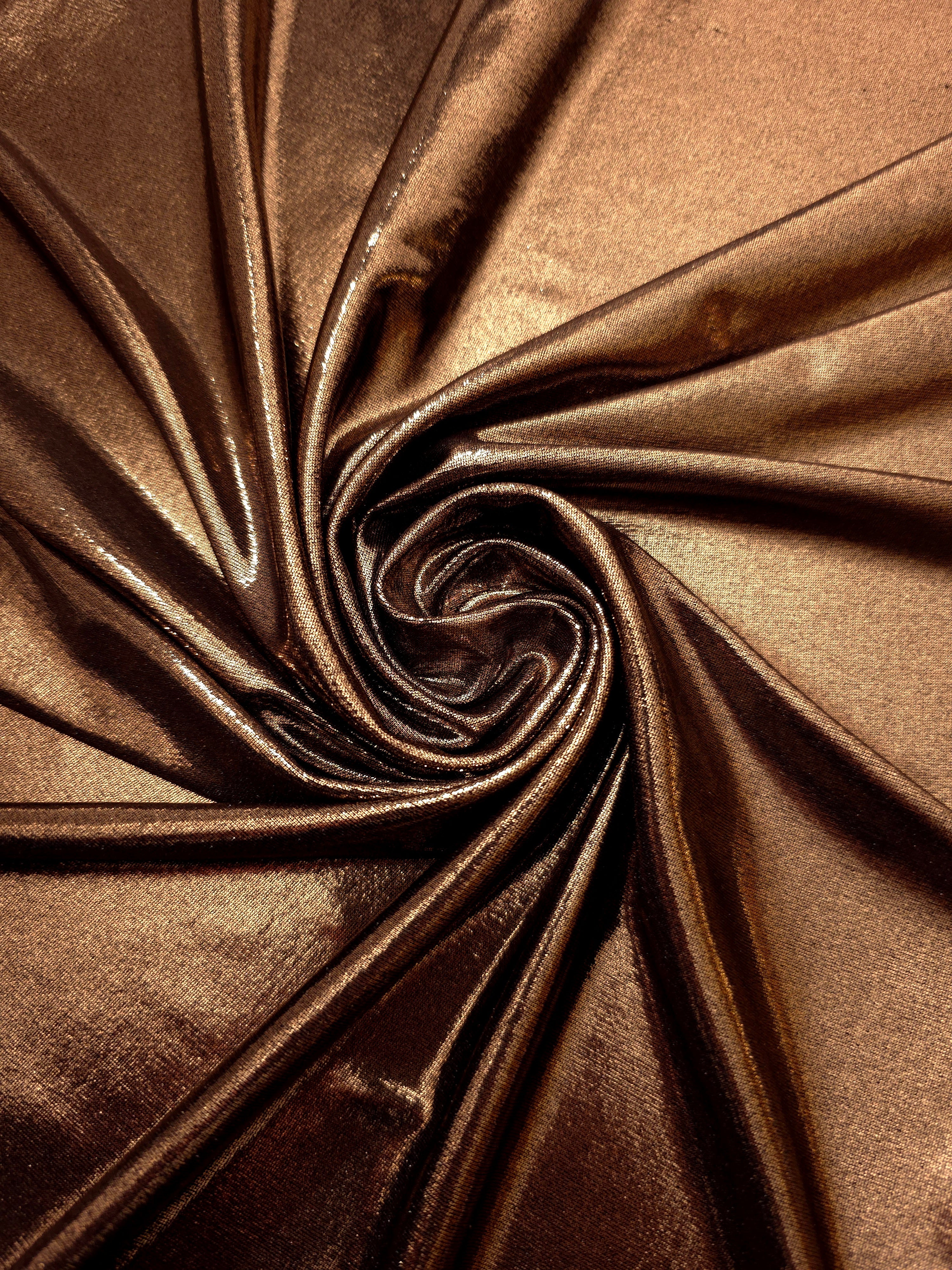 Copper Brown shimmer foiled stretch fabric arranged in a swirl, highlighting movement and reflective finish for performancewear