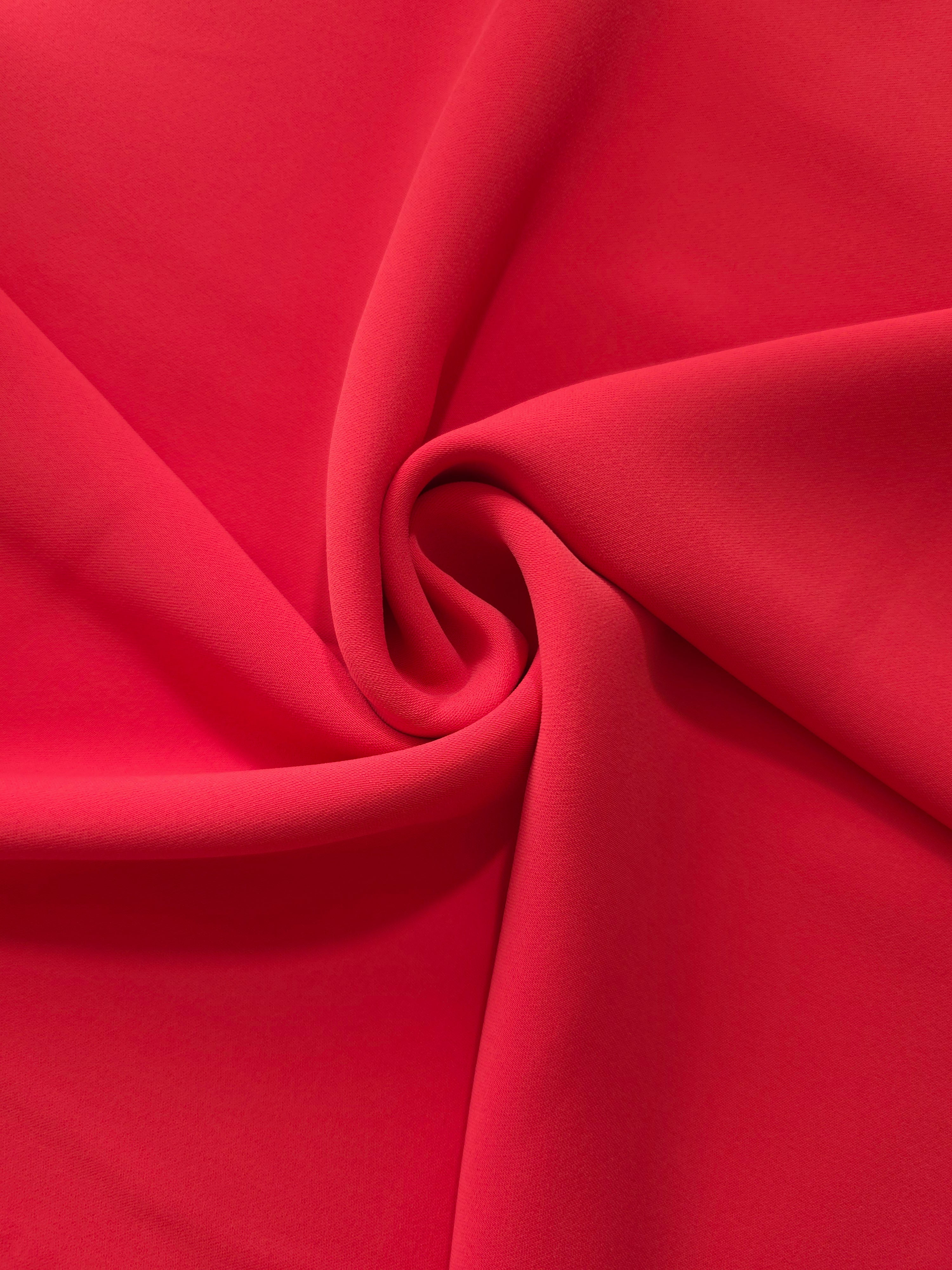 Flowing swirl of Crimson Red polyester crepe showing soft movement for blouses, dresses and abayas