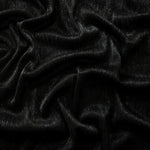 Draped Charcoal Black Sheer Metallic Shimmer Stretch Tulle Fabric showing luminous reflective folds, soft transparency and flexible flow for dresses, dancewear, stagewear and occasion looks