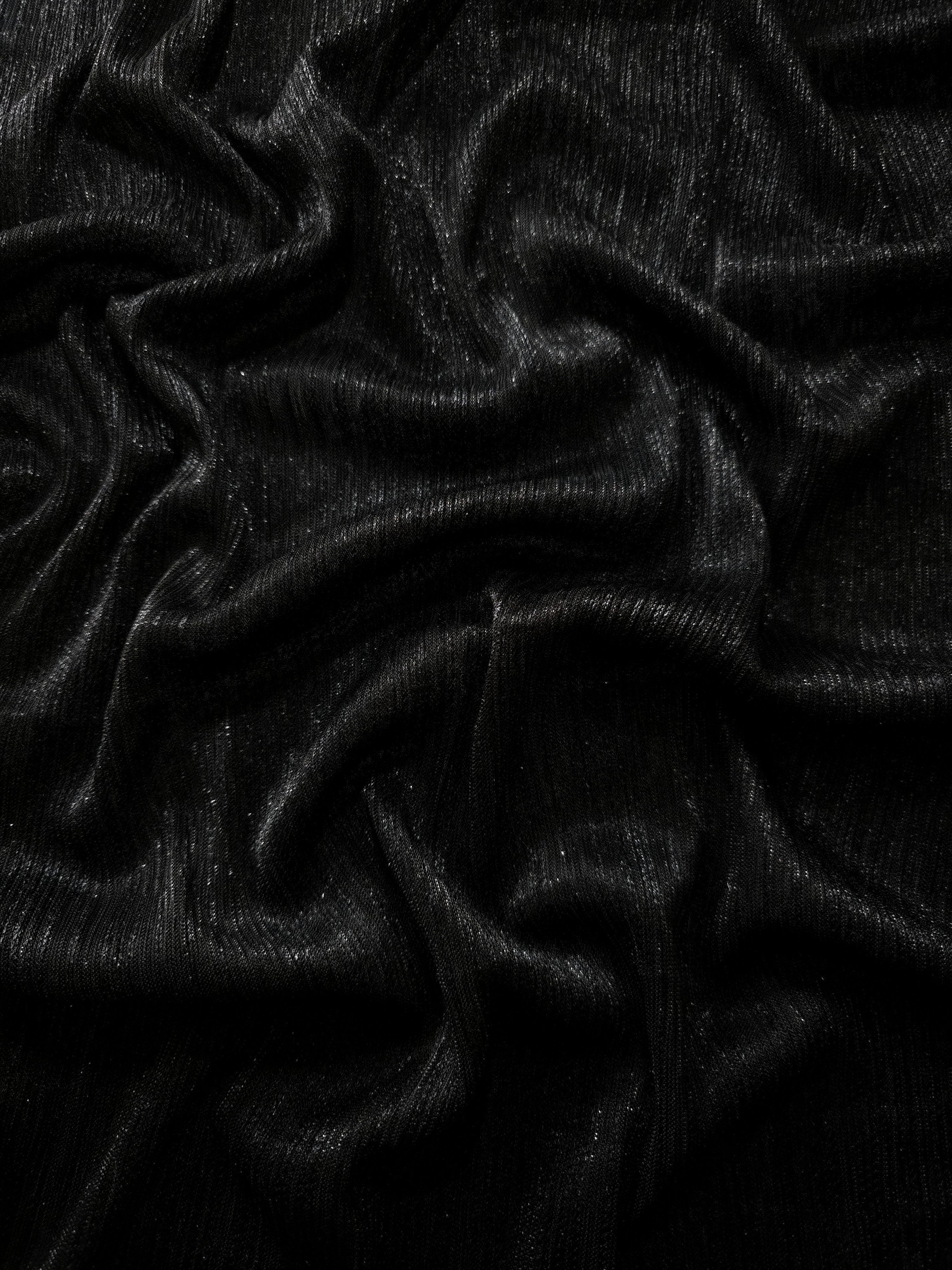 Draped Charcoal Black Sheer Metallic Shimmer Stretch Tulle Fabric showing luminous reflective folds, soft transparency and flexible flow for dresses, dancewear, stagewear and occasion looks