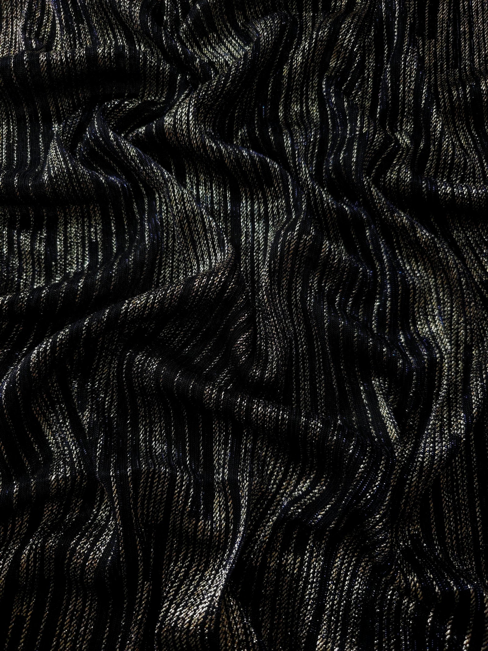 Draped Jet Black Sheer Metallic Shimmer Stretch Tulle Fabric showing luminous reflective folds, soft transparency and flexible flow for dresses, dancewear, stagewear and occasion looks